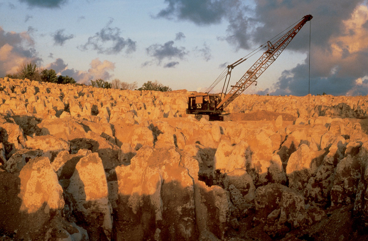 A photograph of a crane extracting coral pinnacles on Nauru.