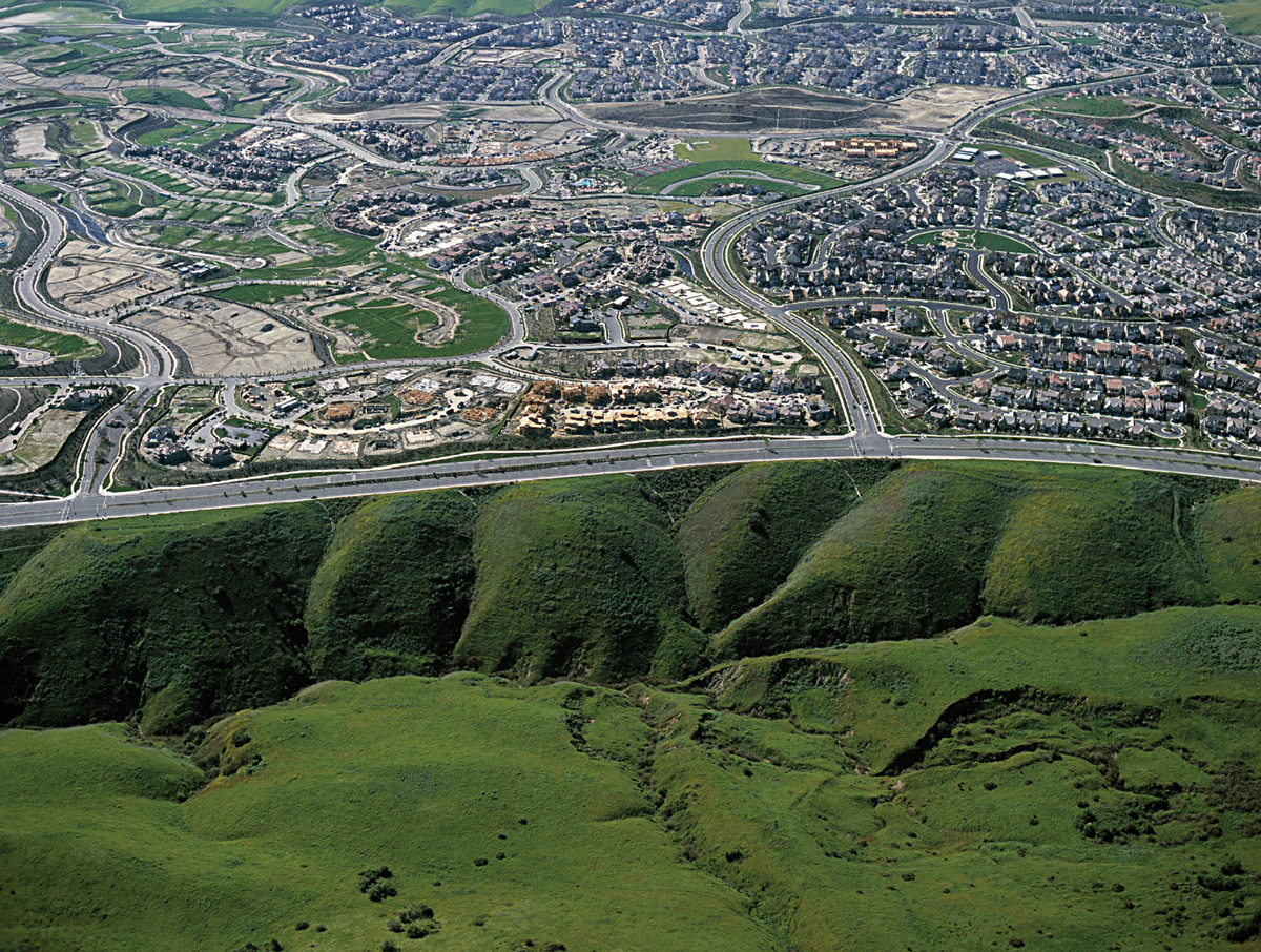 An aerial photograph of plastid-implanted hillocks adjacent to housing in Irvine, California.