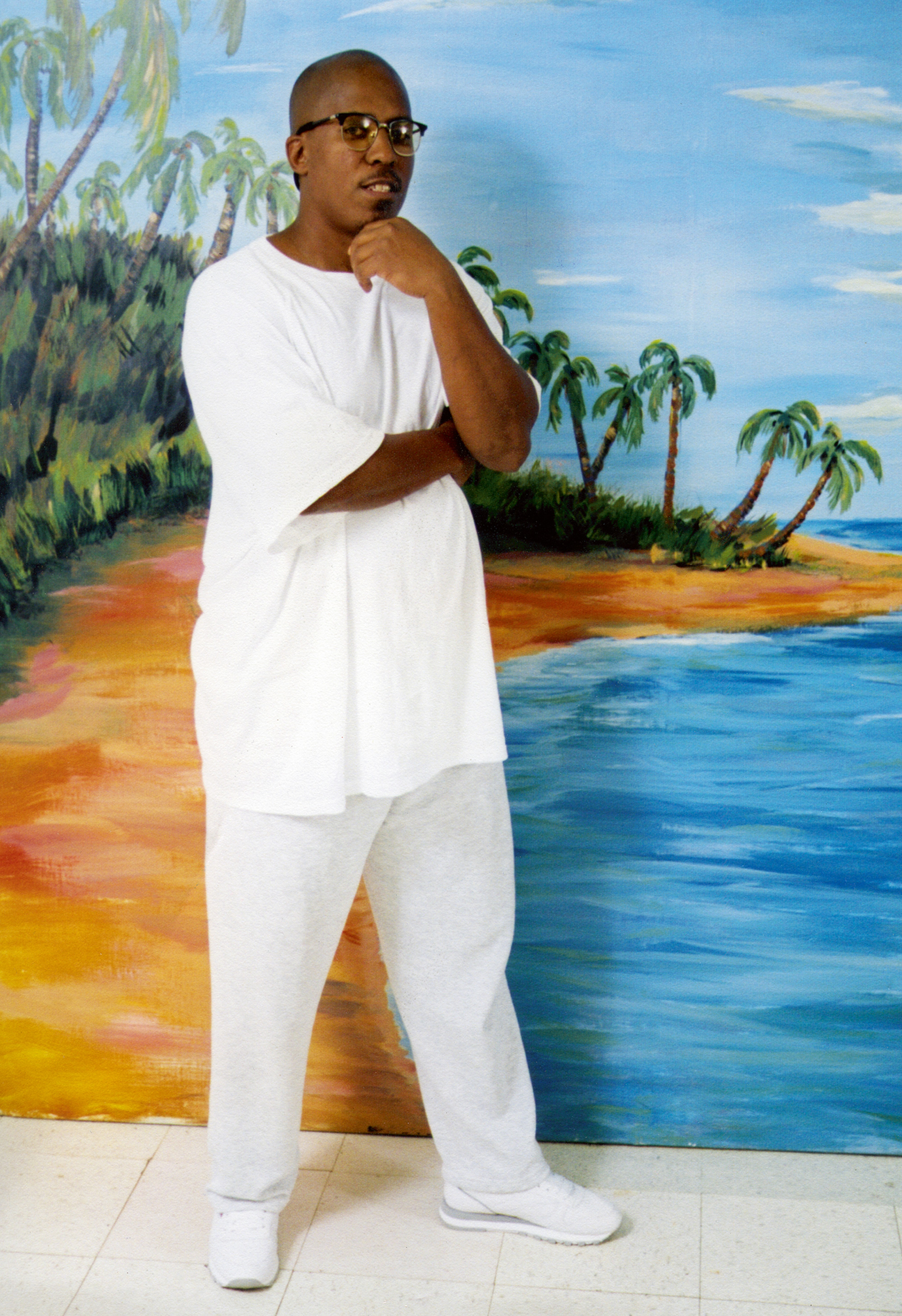 A photograph of R. RuffBey in front of a mural at the United States Penitentiary in Atlanta, Georgia.