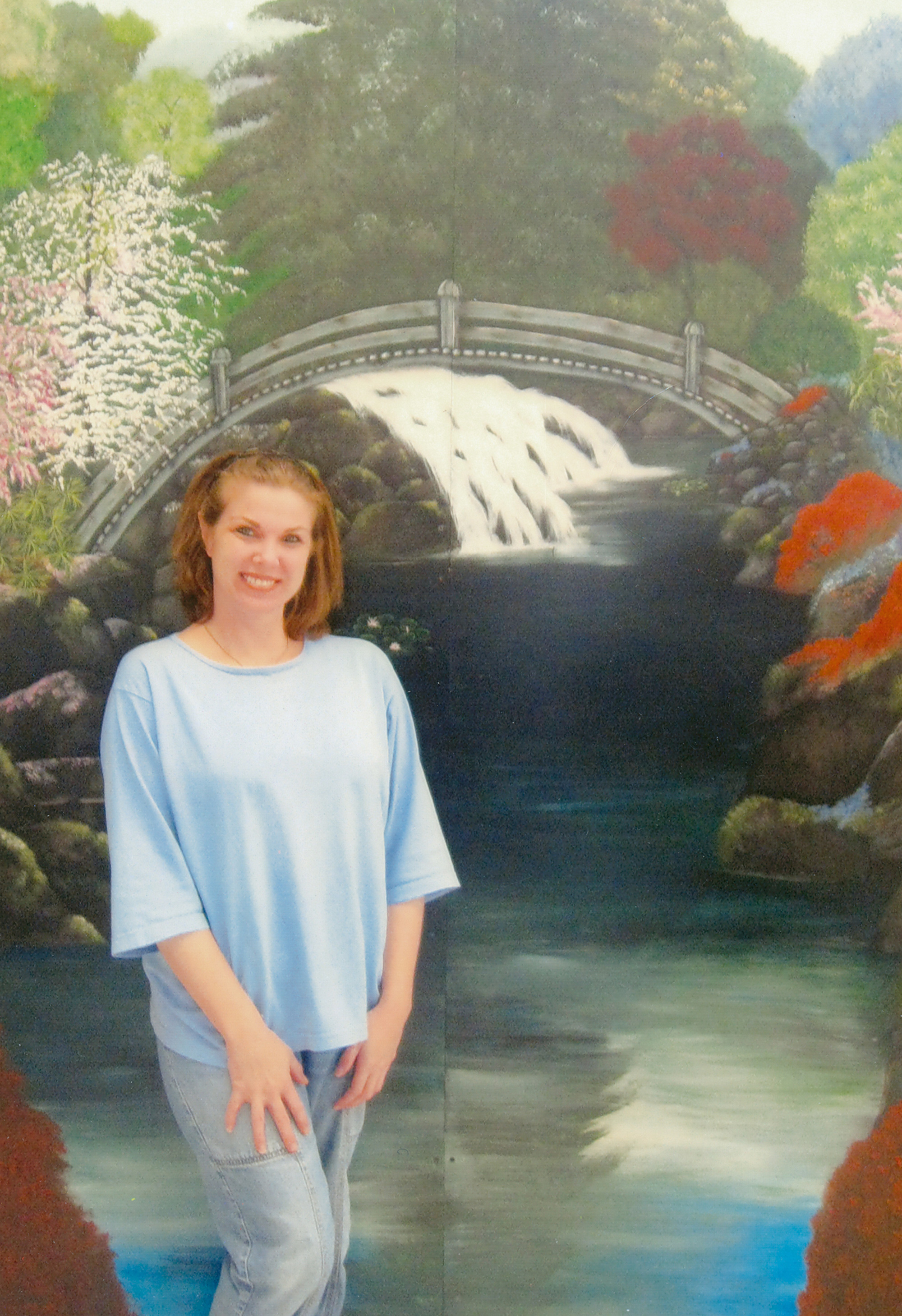 A photograph of Kimberly Buntyn in front of a mural at the Valley State Prison for Women in Chowchilla, California.