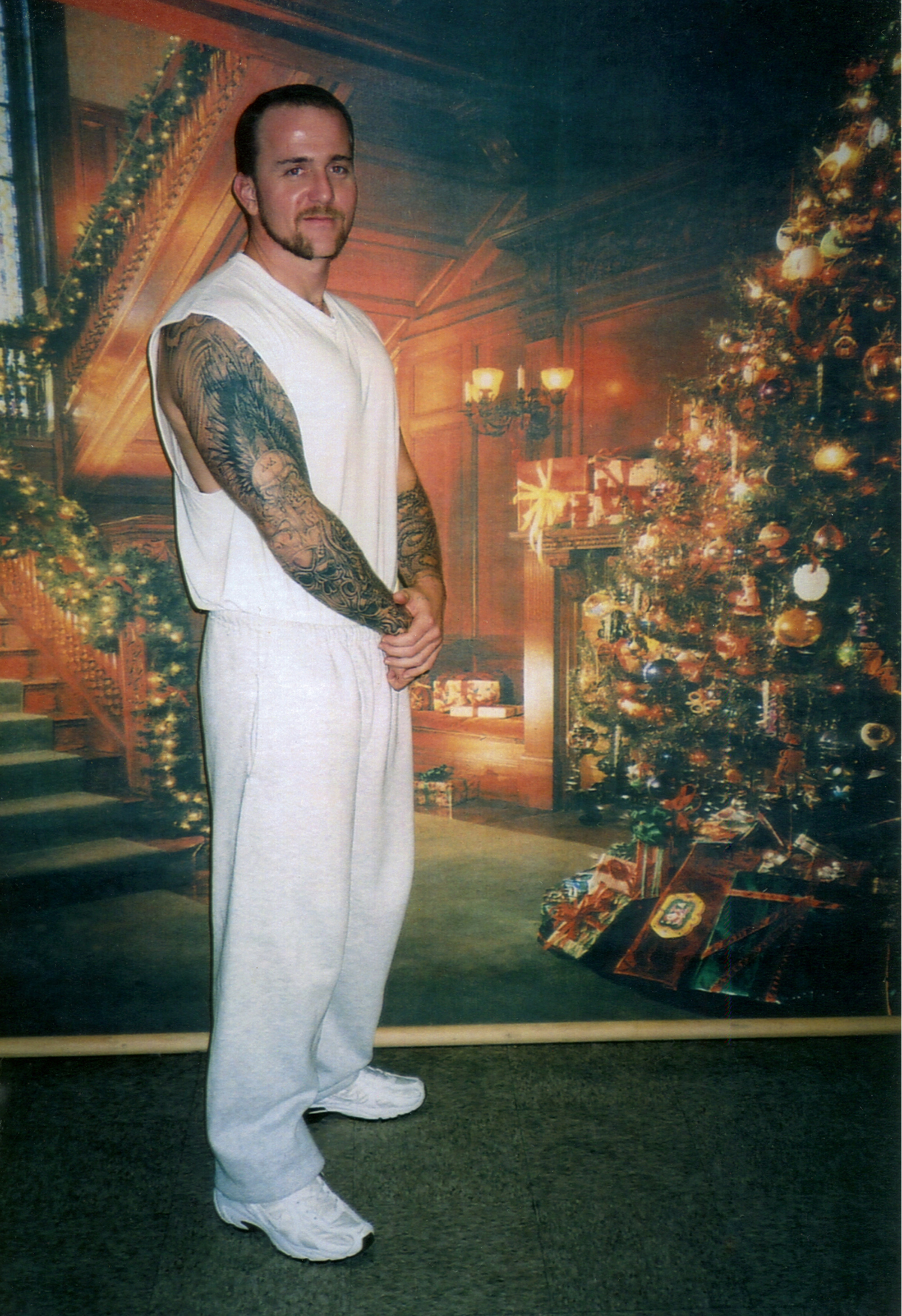 A photograph of Brandon Jones in front of a mural at the Unites States Penitentiary in Marion, Illinois.