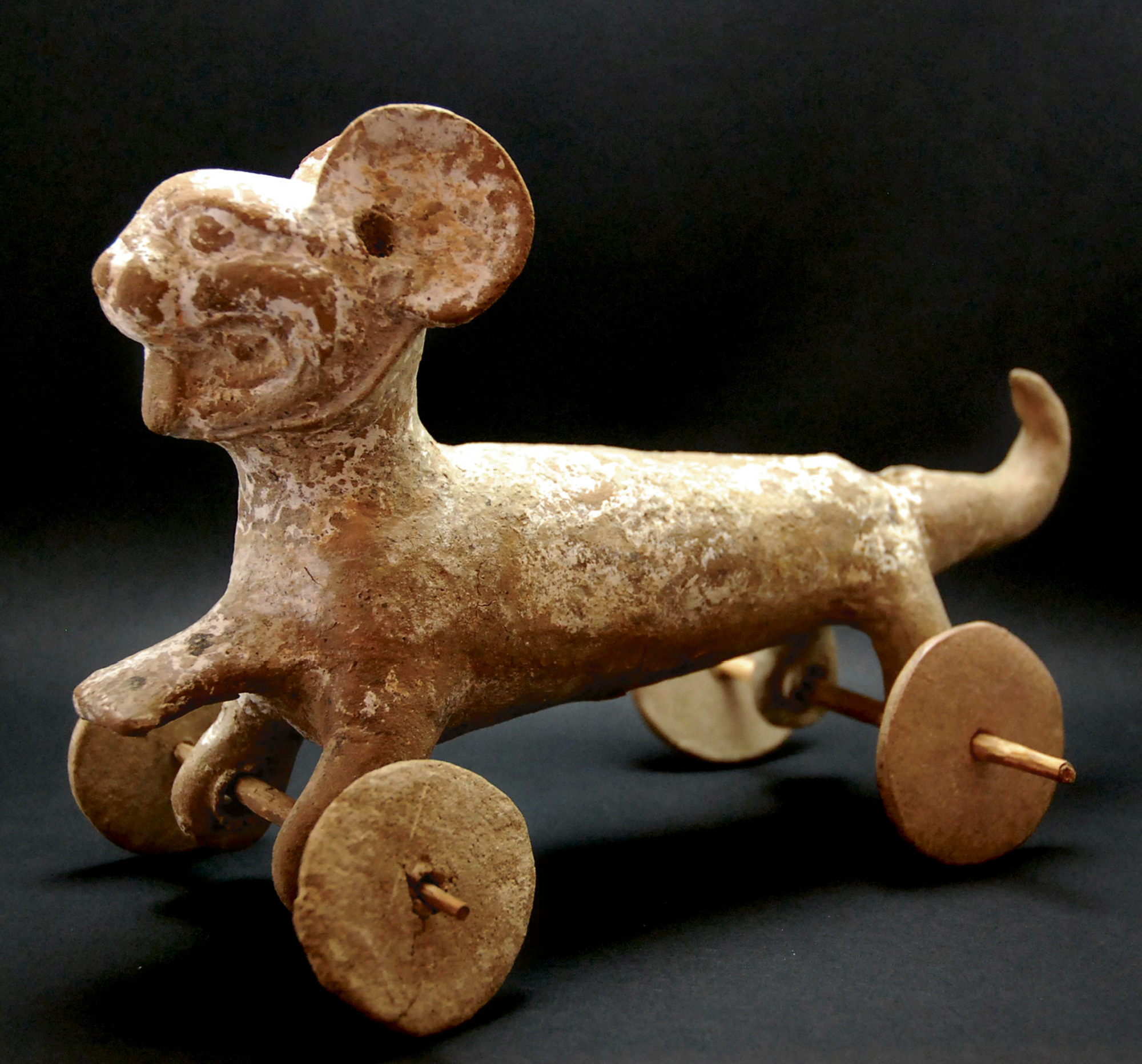 A small figurine of an animal with wheels for legs.