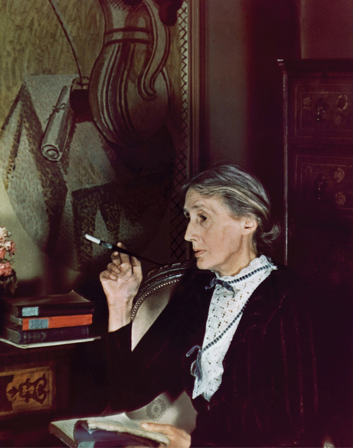 A nineteen thirty nine photograph of Virginia Woolf smoking while reading.