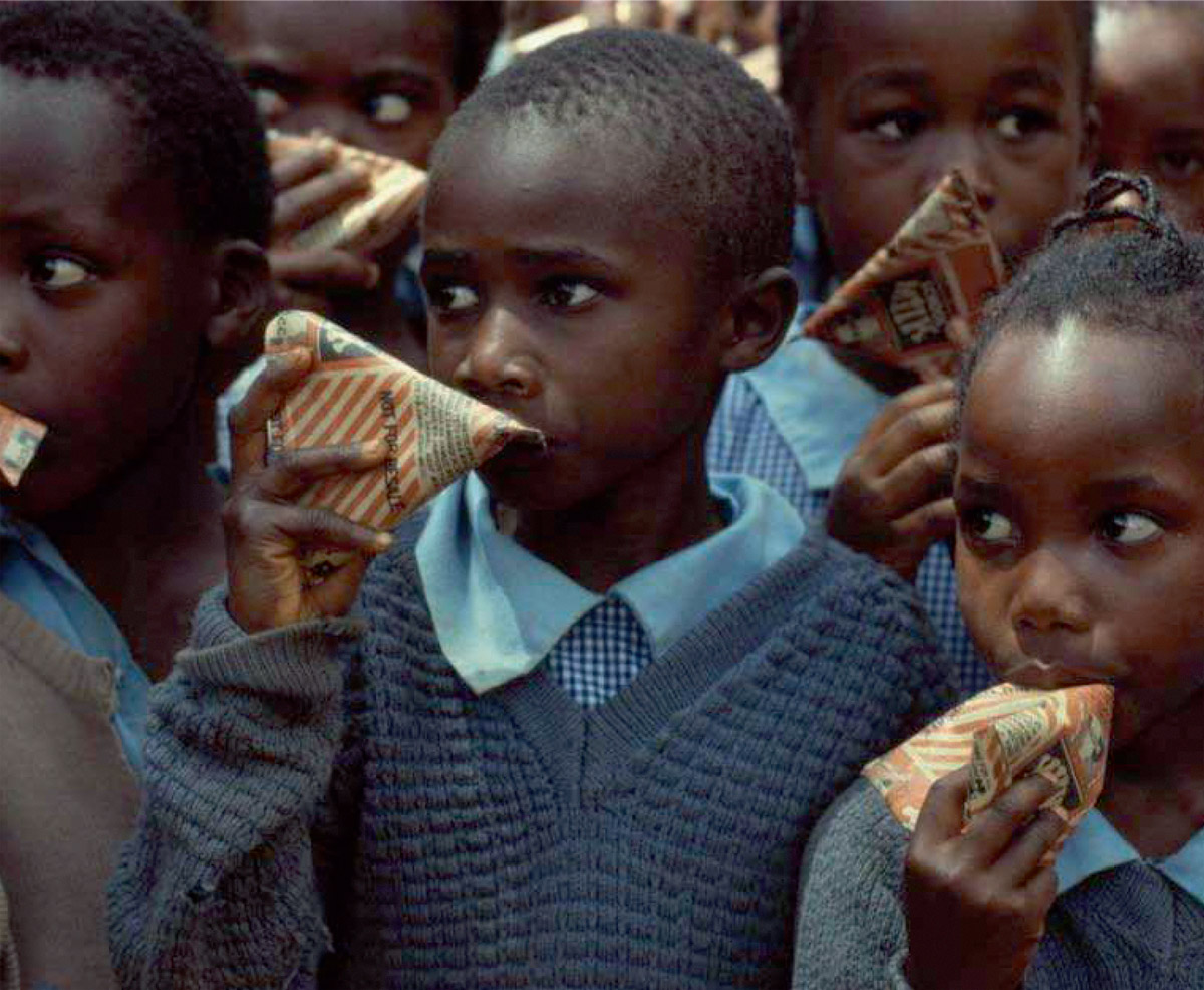 An image from the May two thousand twelve Tetra Pak Dairy Index number five, showing a group of African children holding Tetra Pak milk packets. The region is what Tetra Pak calls “the bottom of the pyramid.”