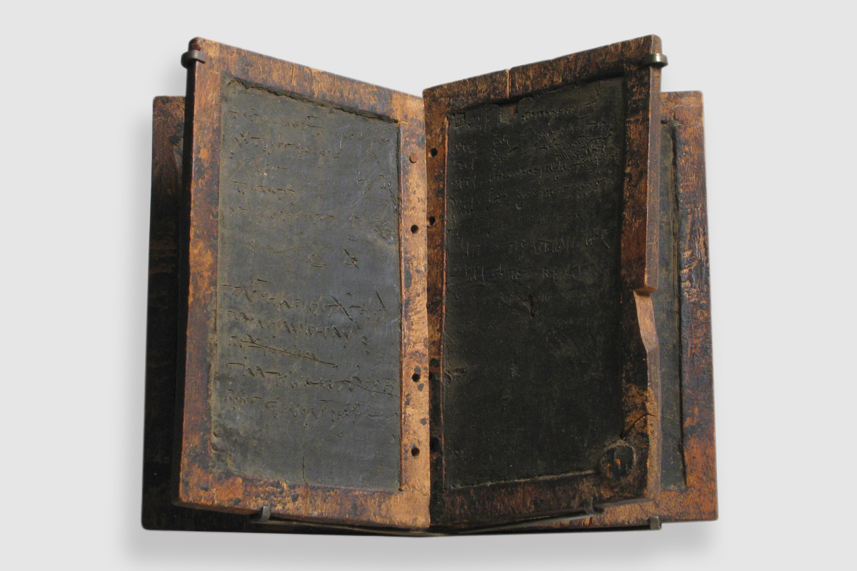 A photograph of a rectangular wooden writing tablet with various inscriptions, circa five hundred to seven hundred AD, made in Byzantine Egypt.