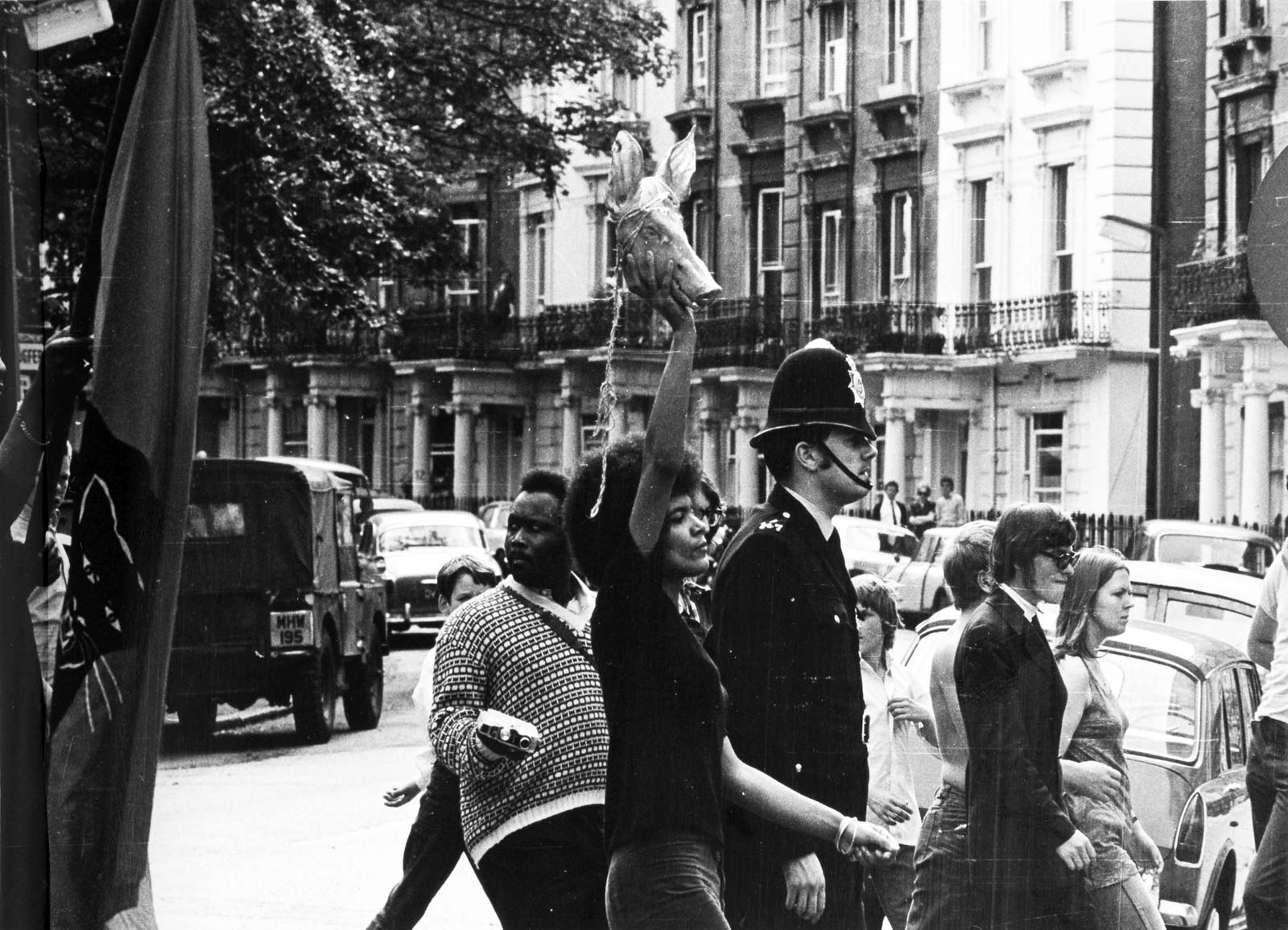 Police photograph of the demonstration in Notting Hill, 9 August 1970. Barbara Beese, who was to be charged as part of the Mangrove Nine, is holding the pig’s head. Image National Archives.