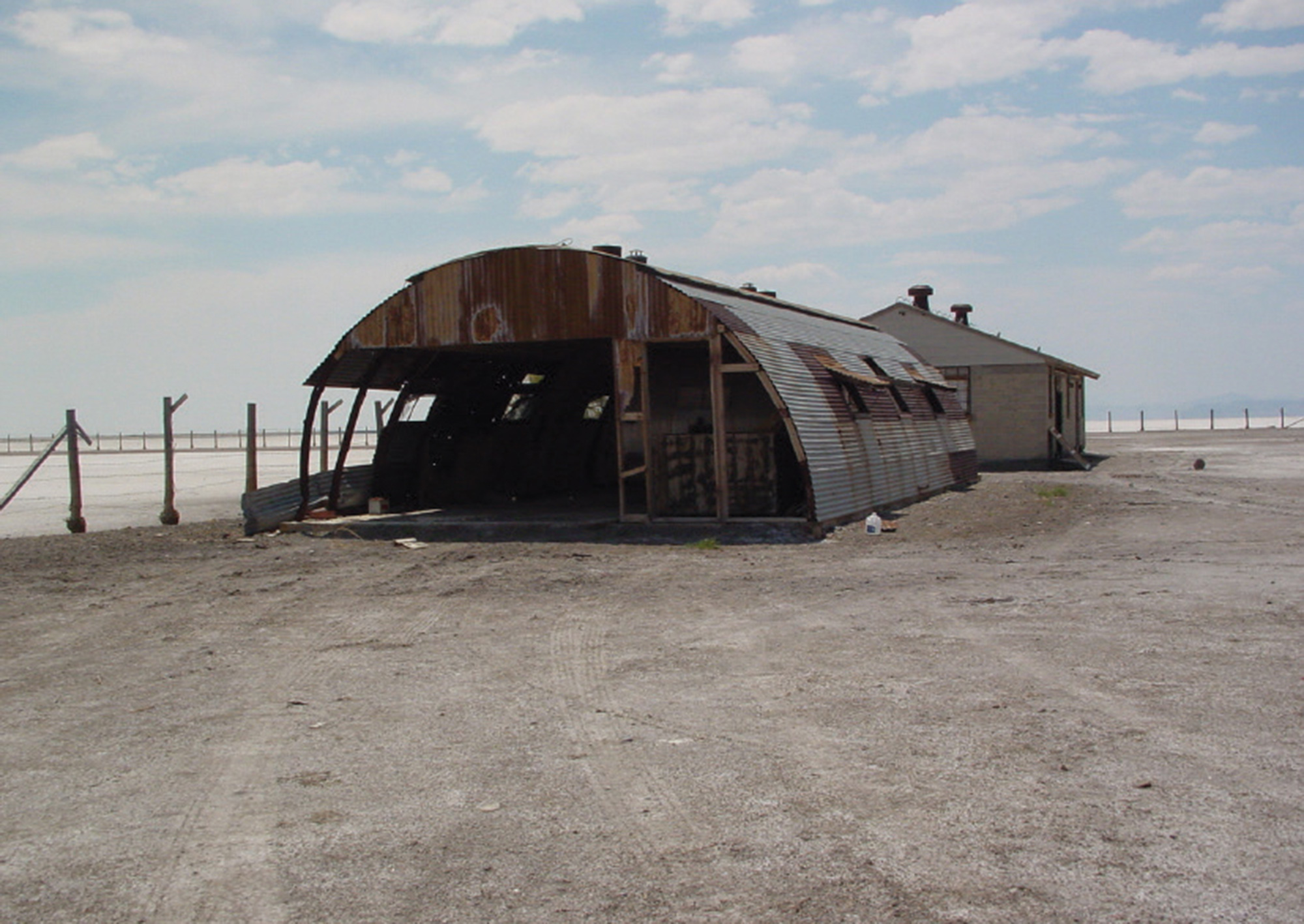 A photograph of a rusting Quonset hut.