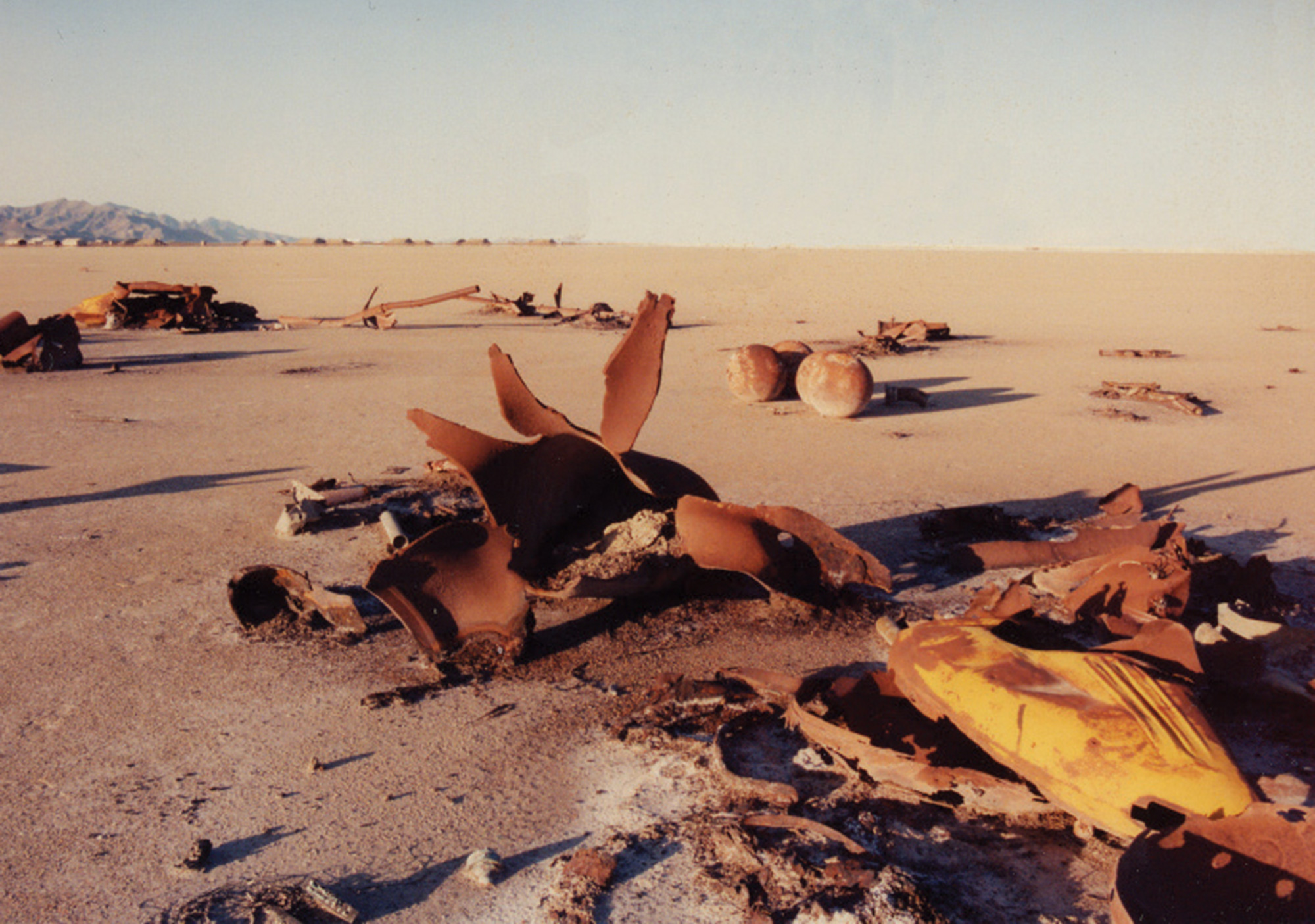 A photograph of blown-out volatile gas containment vessels in a desert testing site.
