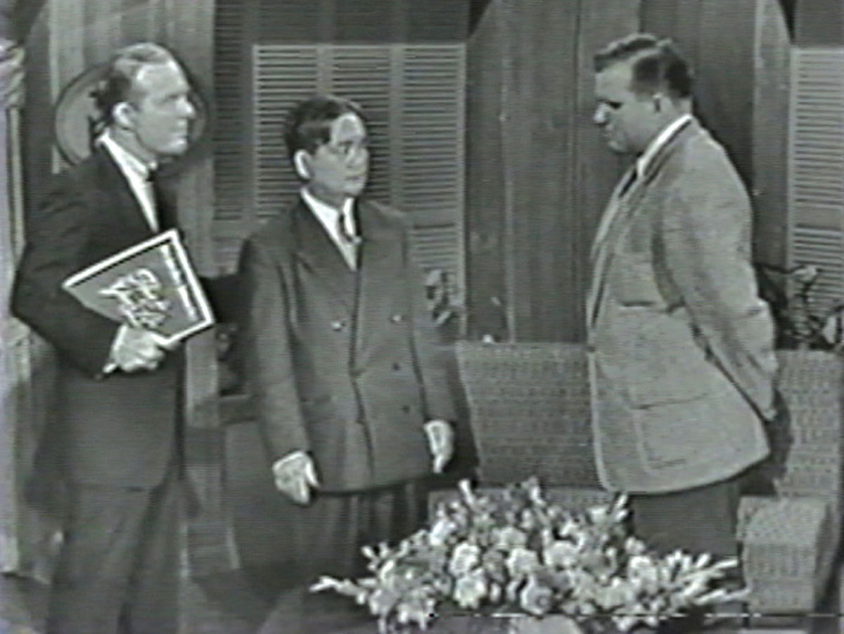 A still image from the 11 May 1955 episode of the television program This Is Your Life, with guests Ralph Edwards, the Reverend Kiyoshi Tanimoto, and Robert Lewis.