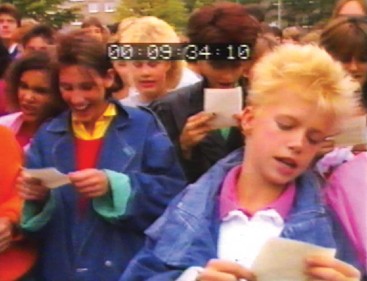 Close-up video still of children reading their sections of Ulysses.