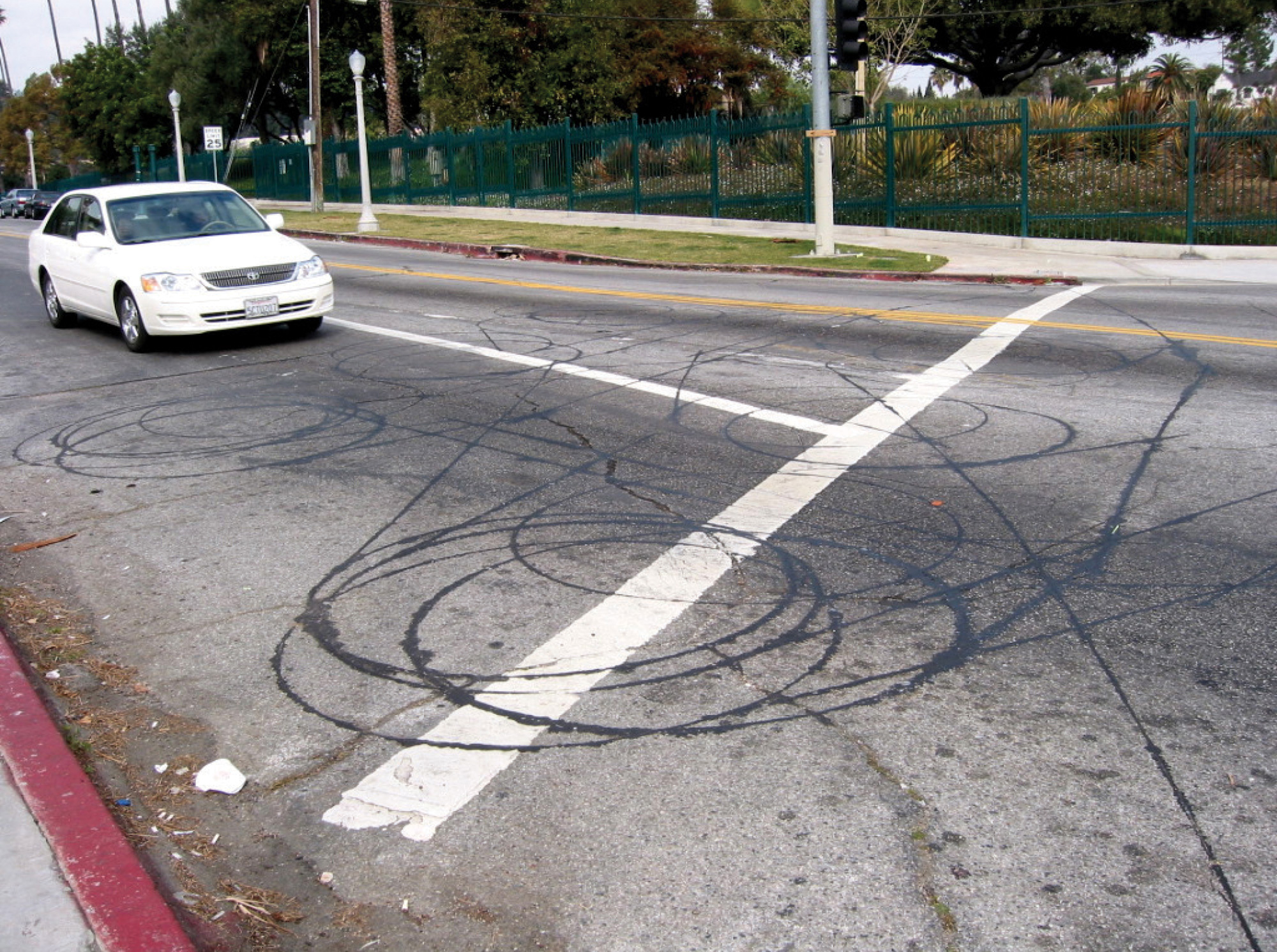 A photograph of a car and tire marks on a road.
