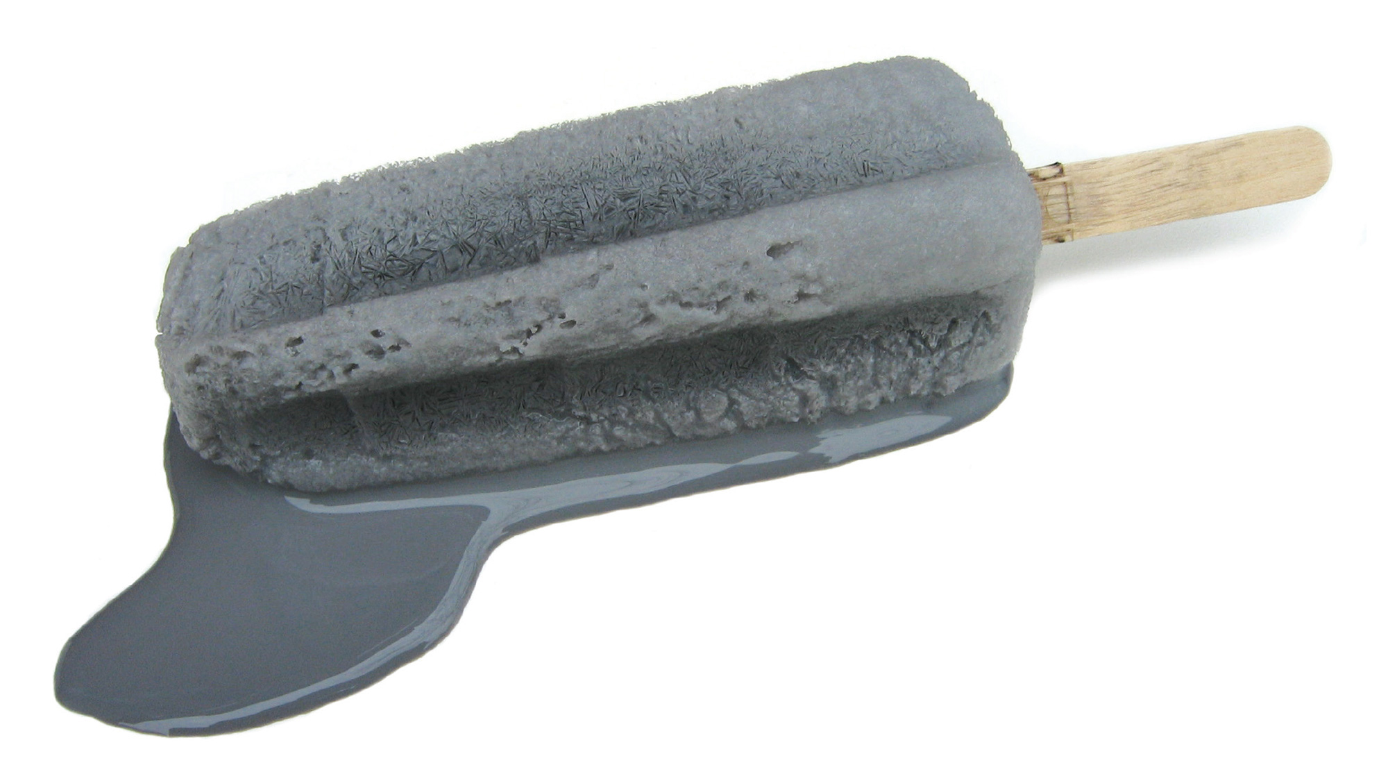 A photograph of a melting popsicle made of frozen milk and grey ink.