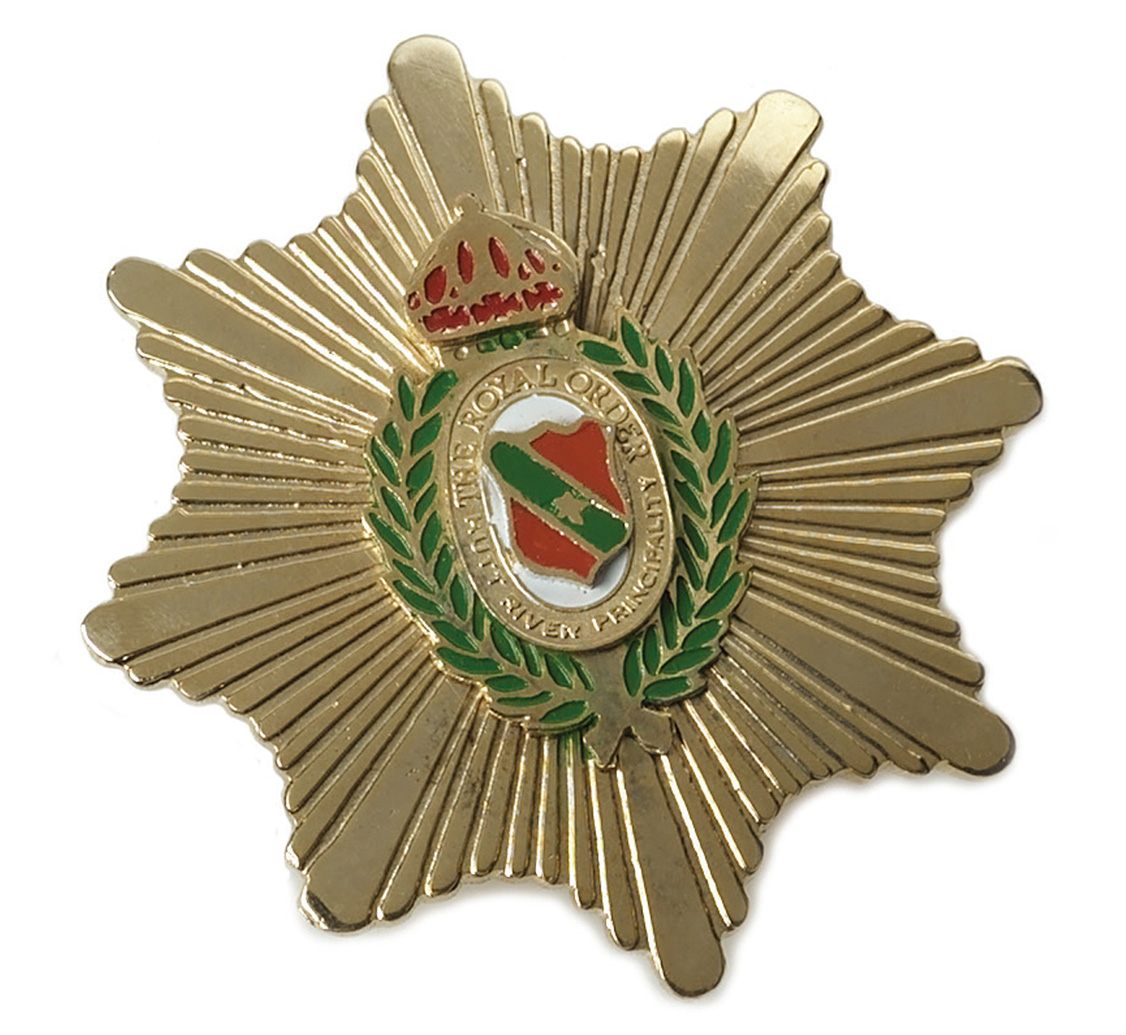 An image of a 1980s gold pin, the Breast Star of the Order of the Unicorn.