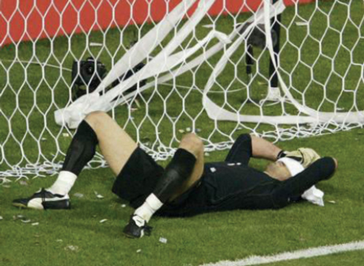 A photograph of Buffon laying down in the goal with a towel over his face. 