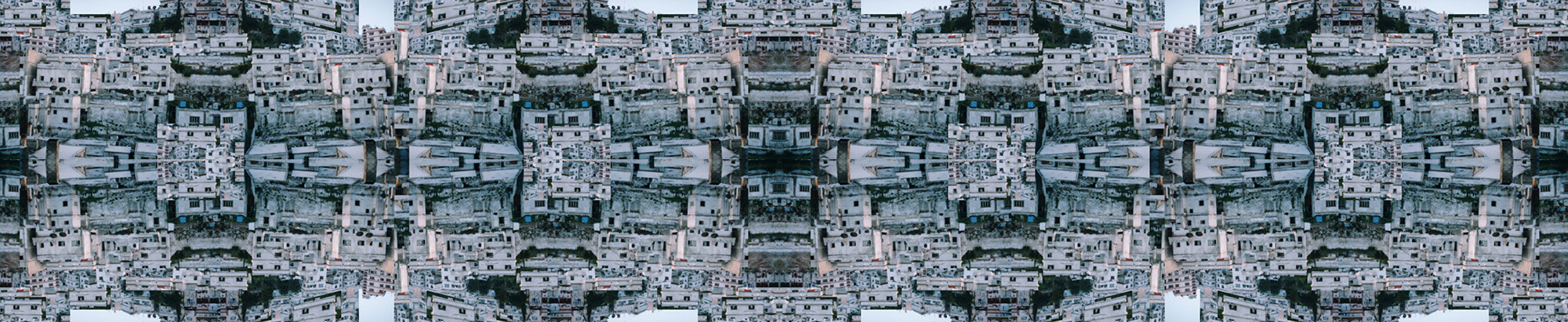 A 2004 artwork by Caitlin Masley, titled “city4ver1,” depicting a photograph of buildings digitally rendered to create symmetrical geometric patterns.