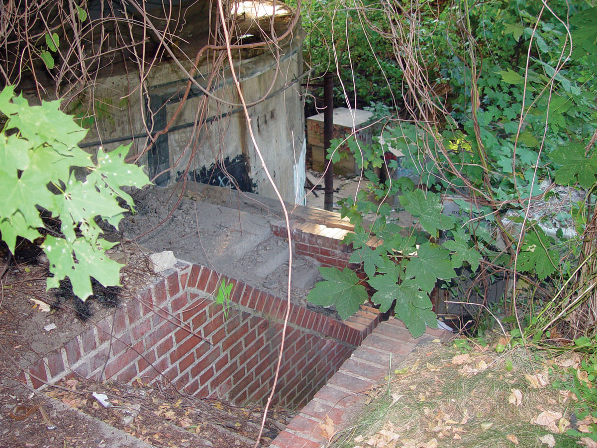 A photograph showing a different angle of the brick staircase and concrete wall.