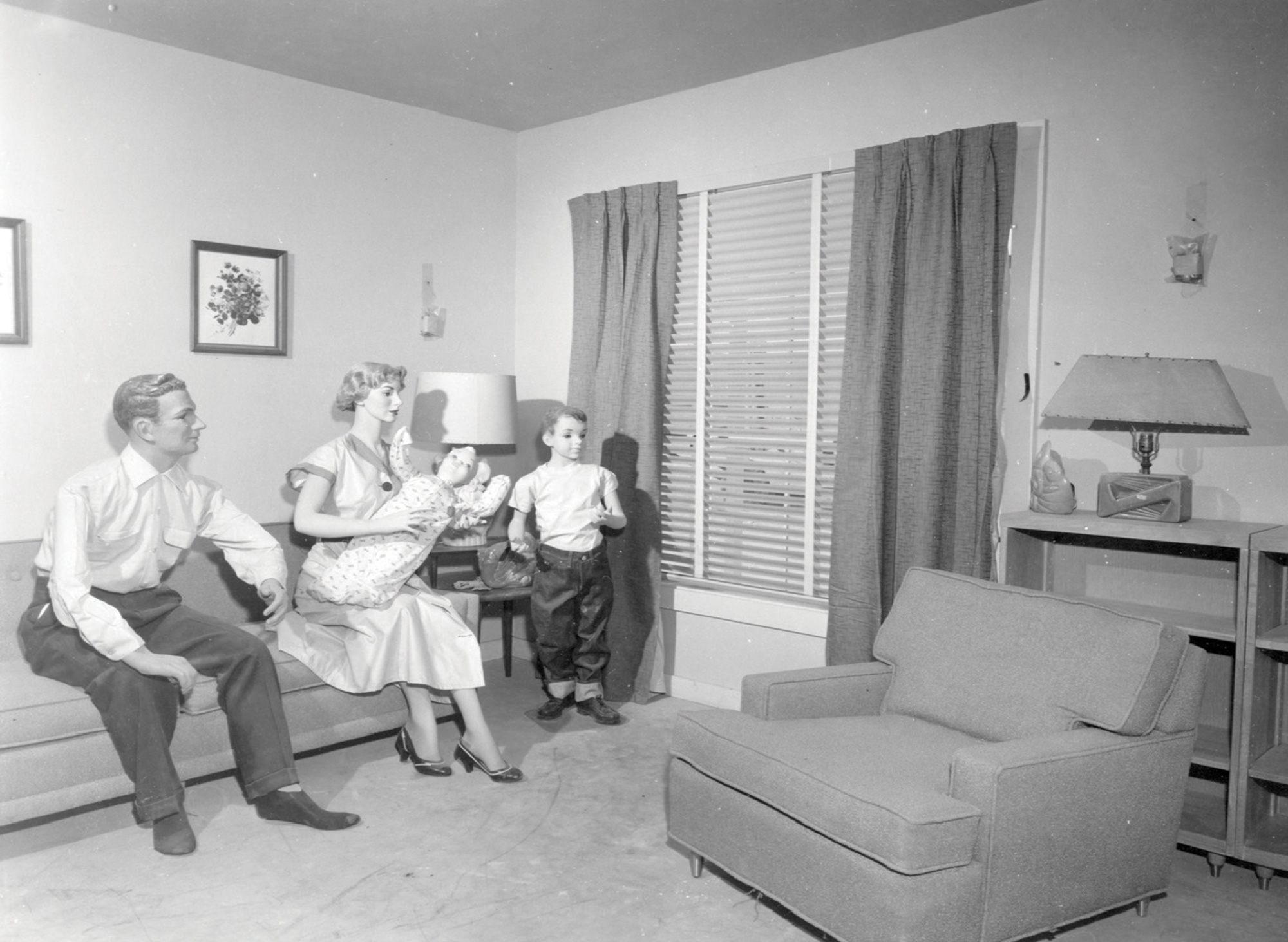 A photograph from Operation Cue depicting a nuclear family sitting in a living room.