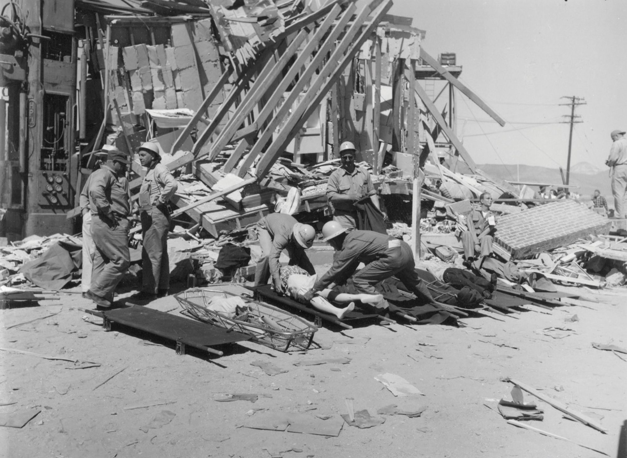 A photograph from Operation Cue depicting workers inspecting the rubble of a house.