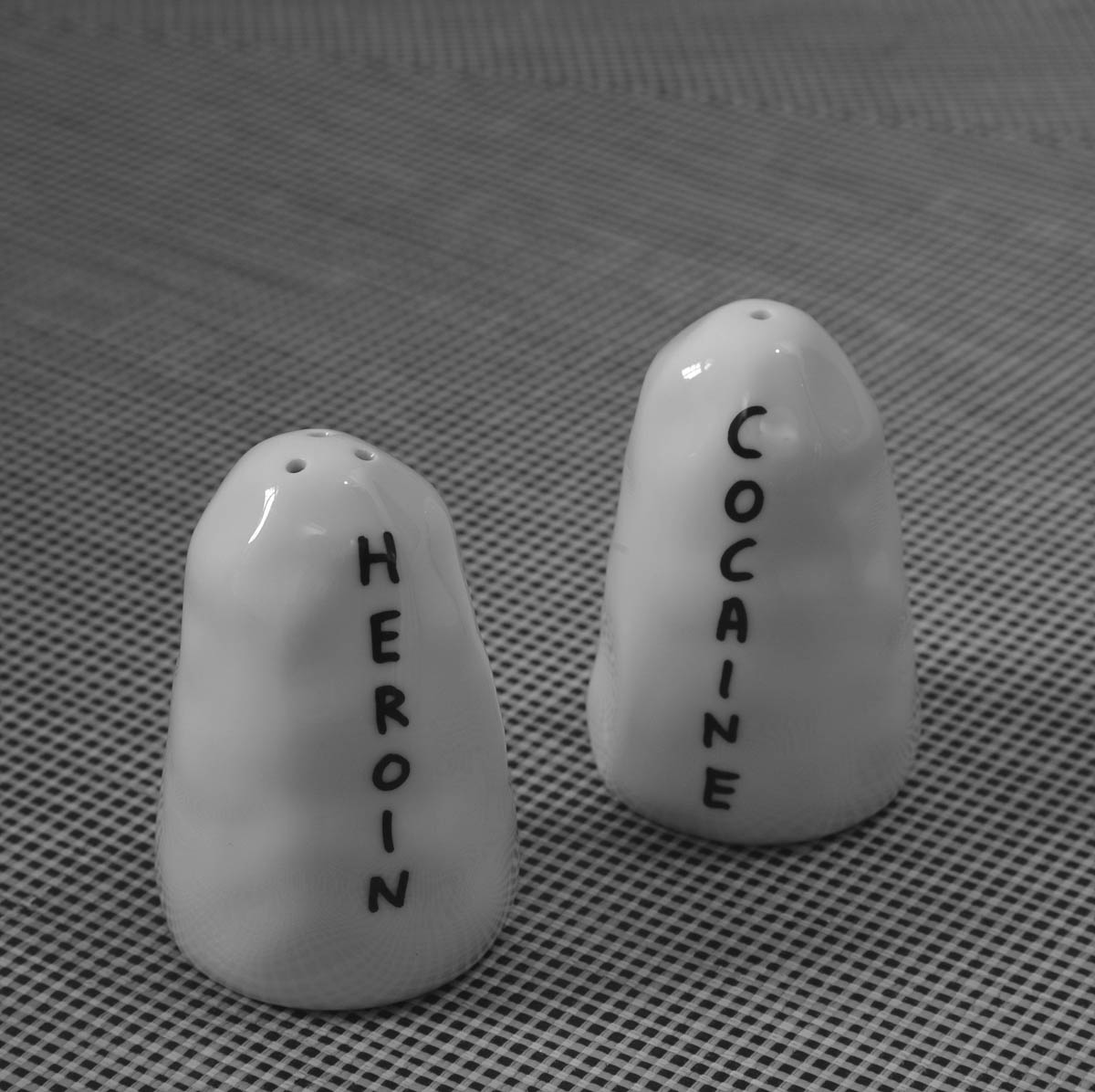 An artwork by David Shrigley consisting of a salt and pepper shaker titled “Heroin/Cocaine,” two thousand.