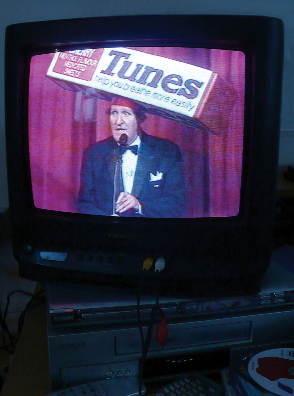 A photograph of Tommy Cooper on a television screen.