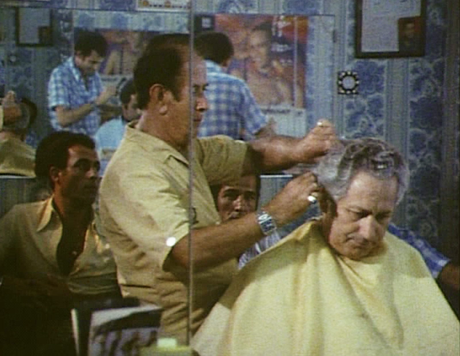 Still from the nineteen eighty five film “Shoah,” by Claude Lanzmann, depicting a scene in a barber shop from various angles.
