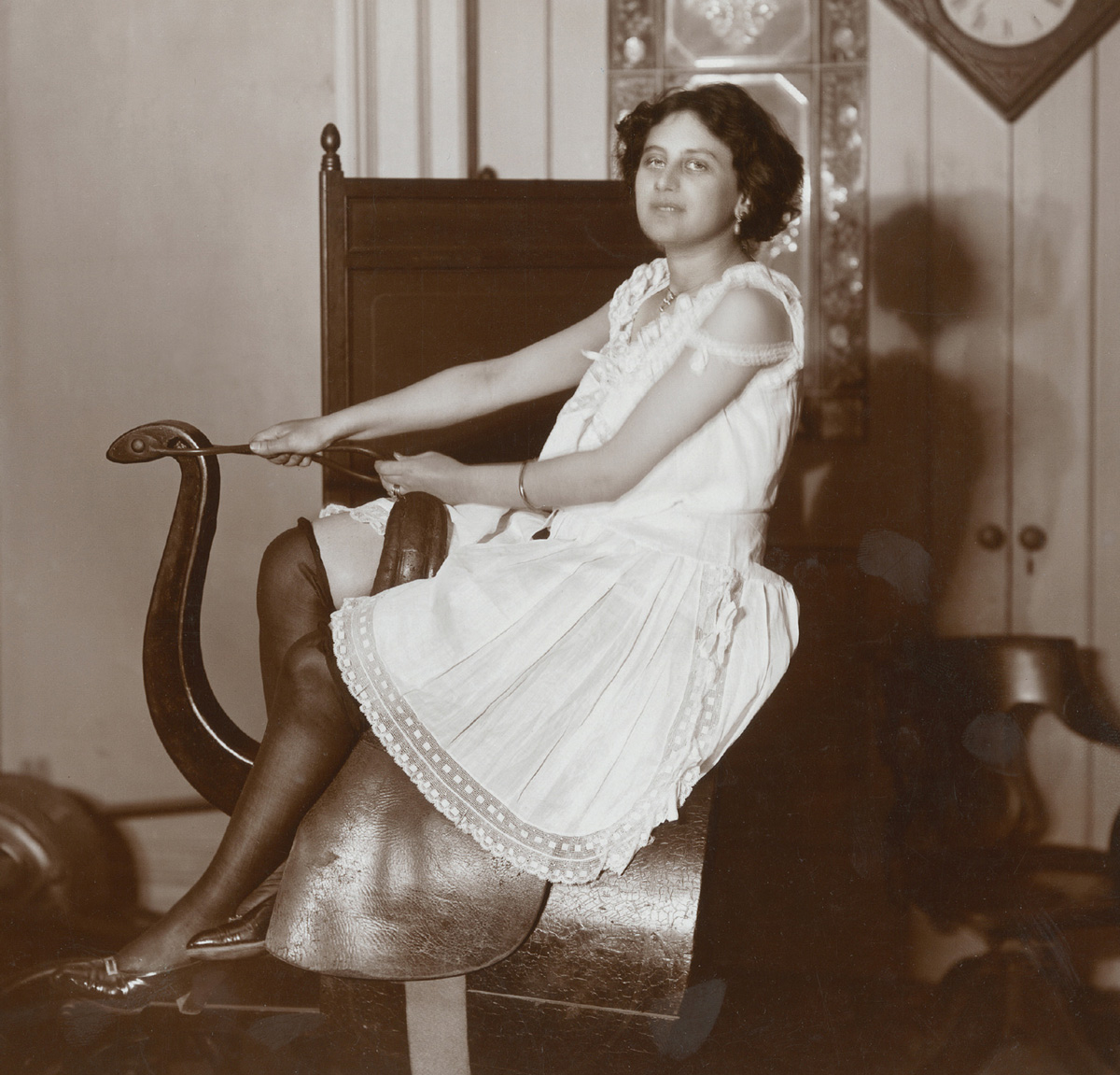 A woman poses on a horse riding simulator at the Zander Institute in New York in nineteen oh eight.