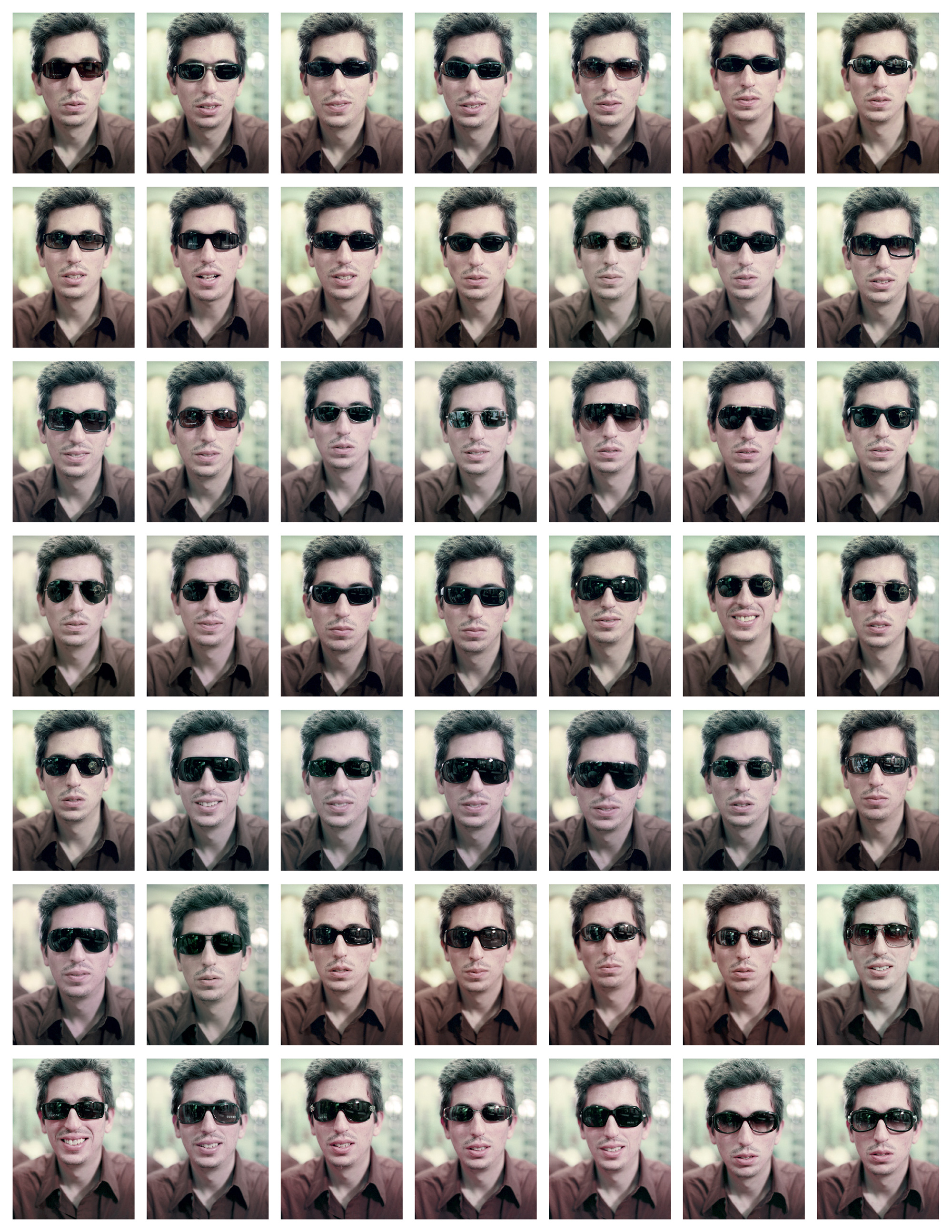 Forty nine small photographs, arranged in a seven by seven grid, of artist San Keller wearing different sunglasses.