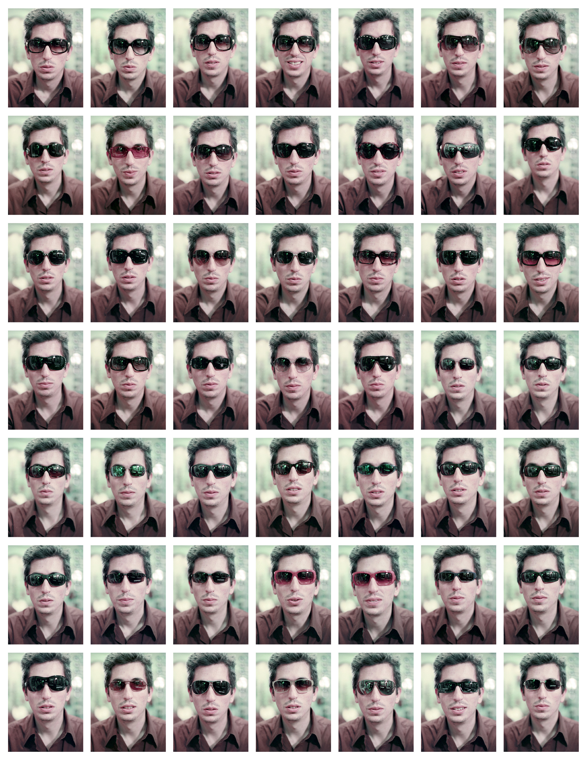 Forty nine small photographs, arranged in a seven by seven grid, of artist San Keller wearing different sunglasses.