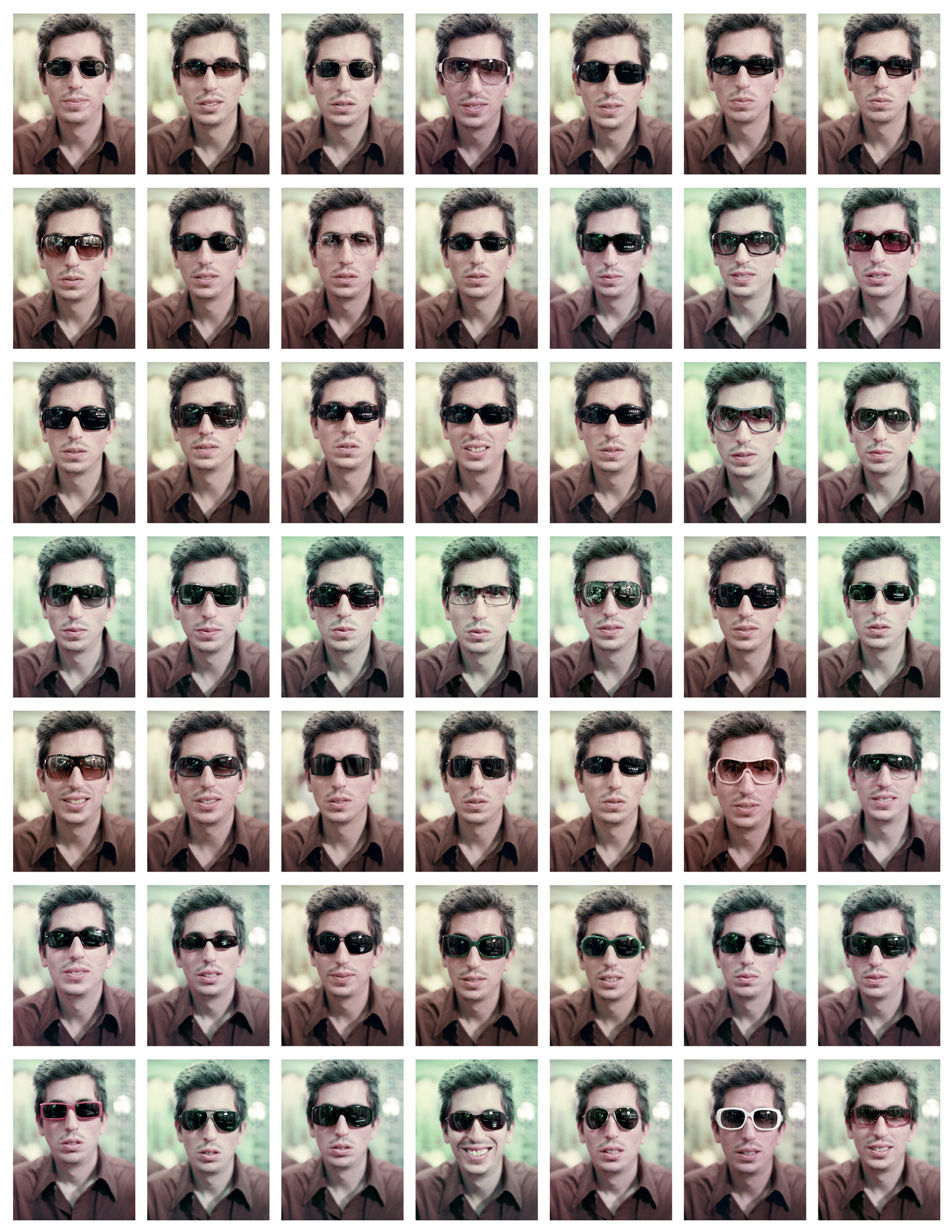 Forty nine small photographs, arranged in a seven by seven grid, of artist San Keller wearing different sunglasses.