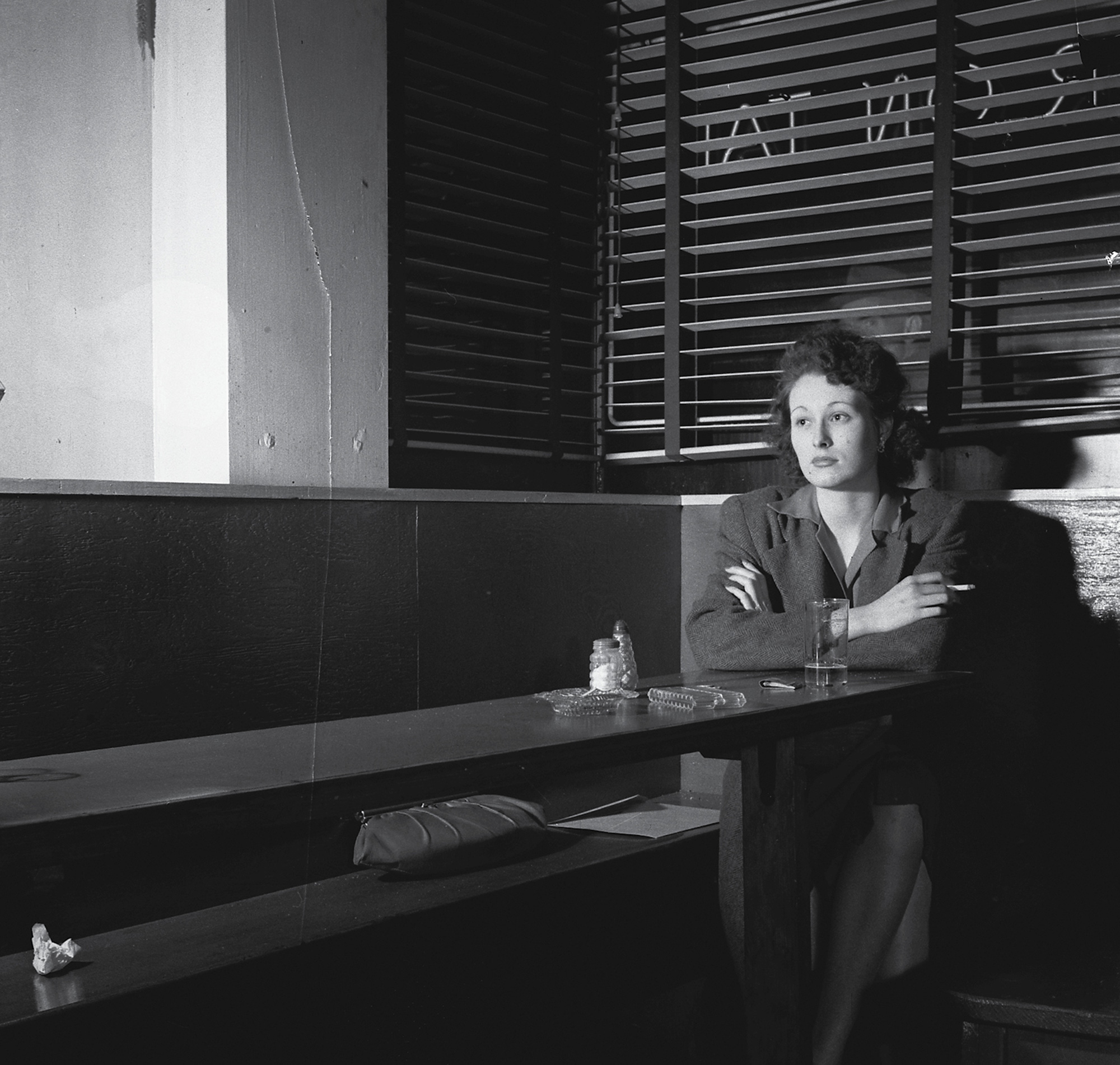 A 1943 photograph of a woman sitting alone at the Sea Grill in Washington, DC. 