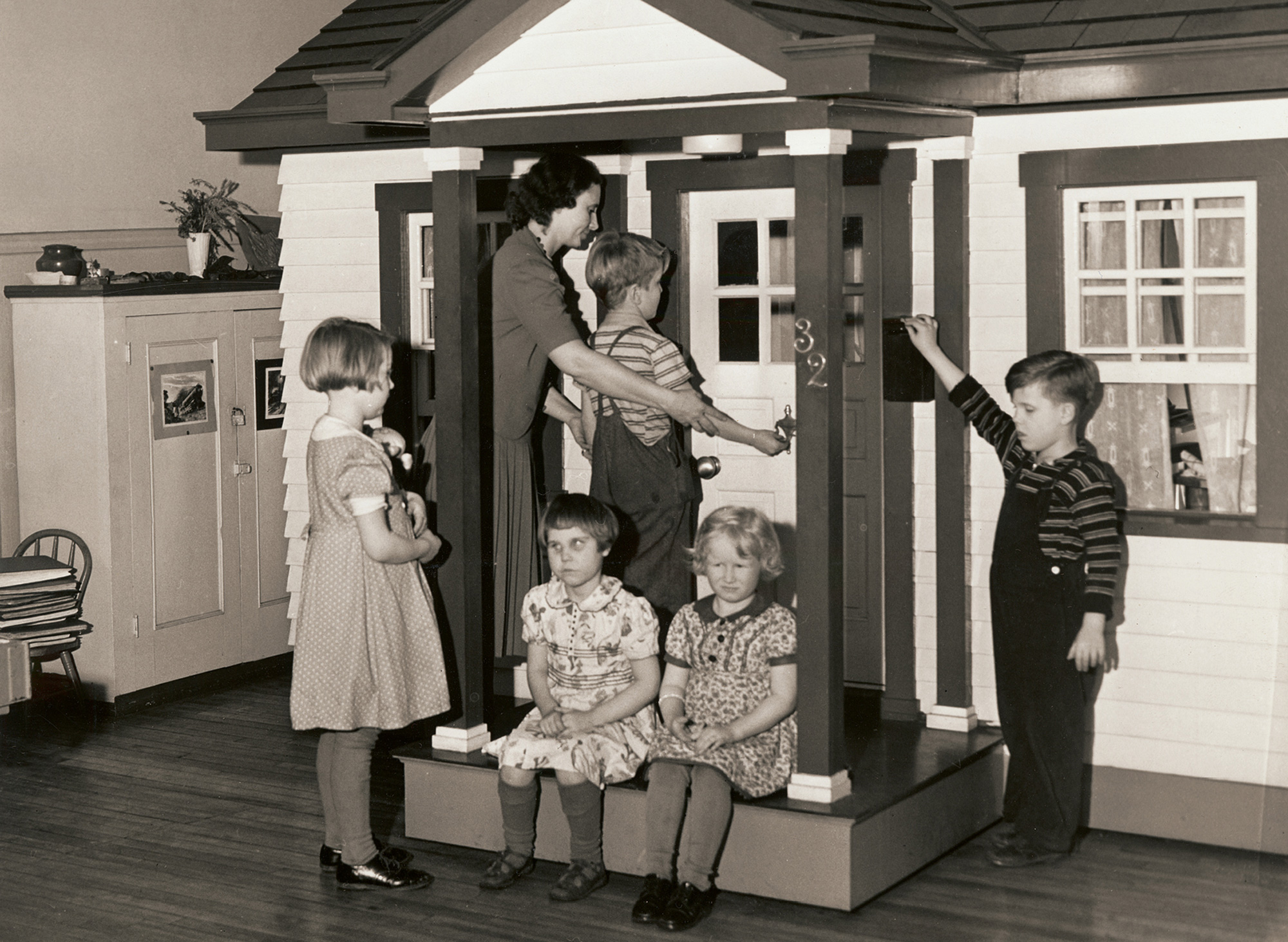 A photograph of children in a three-room playhouse built for the Ohio State School for the Blind. 