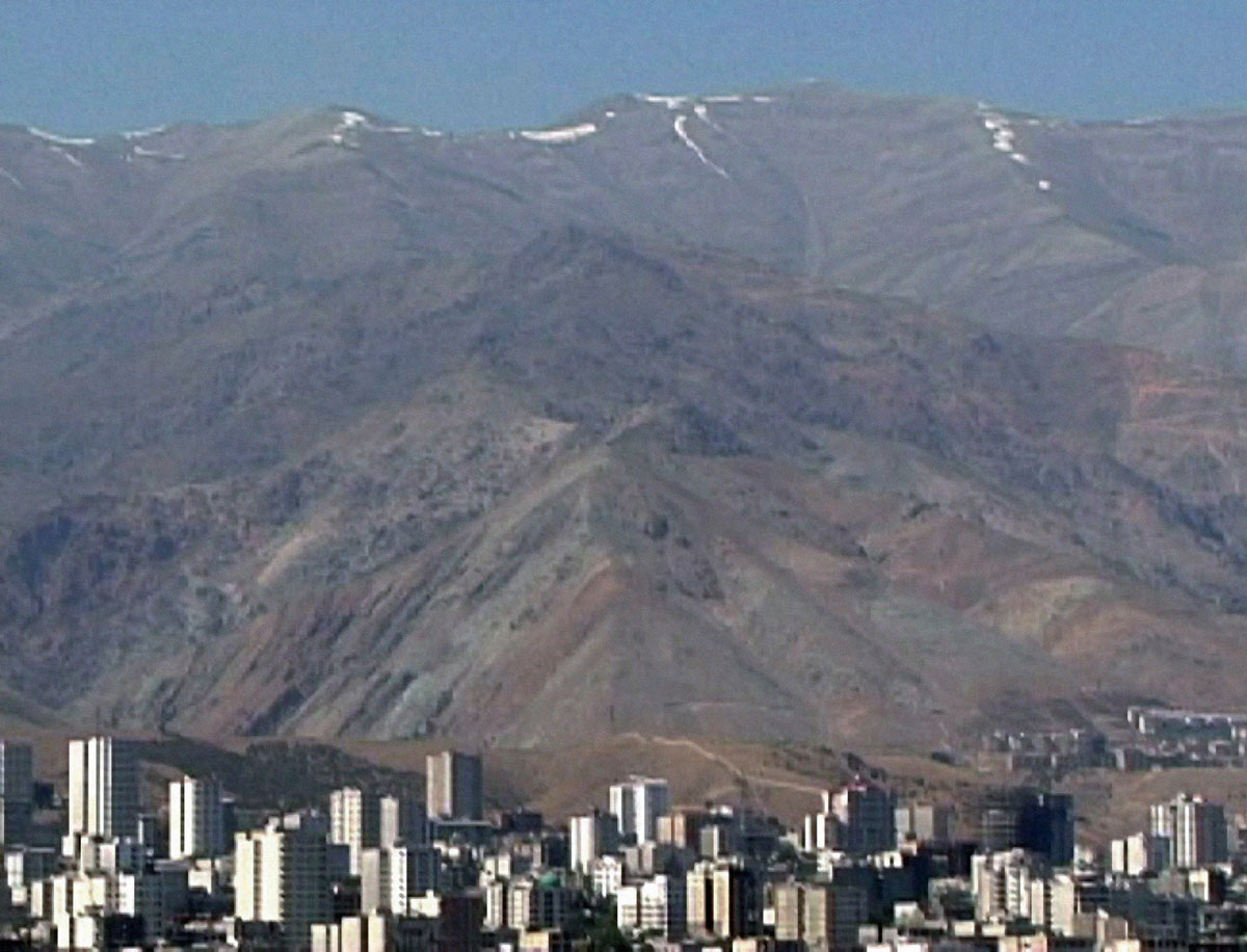A photograph of the city of Evin, Iran with mountains in the background.