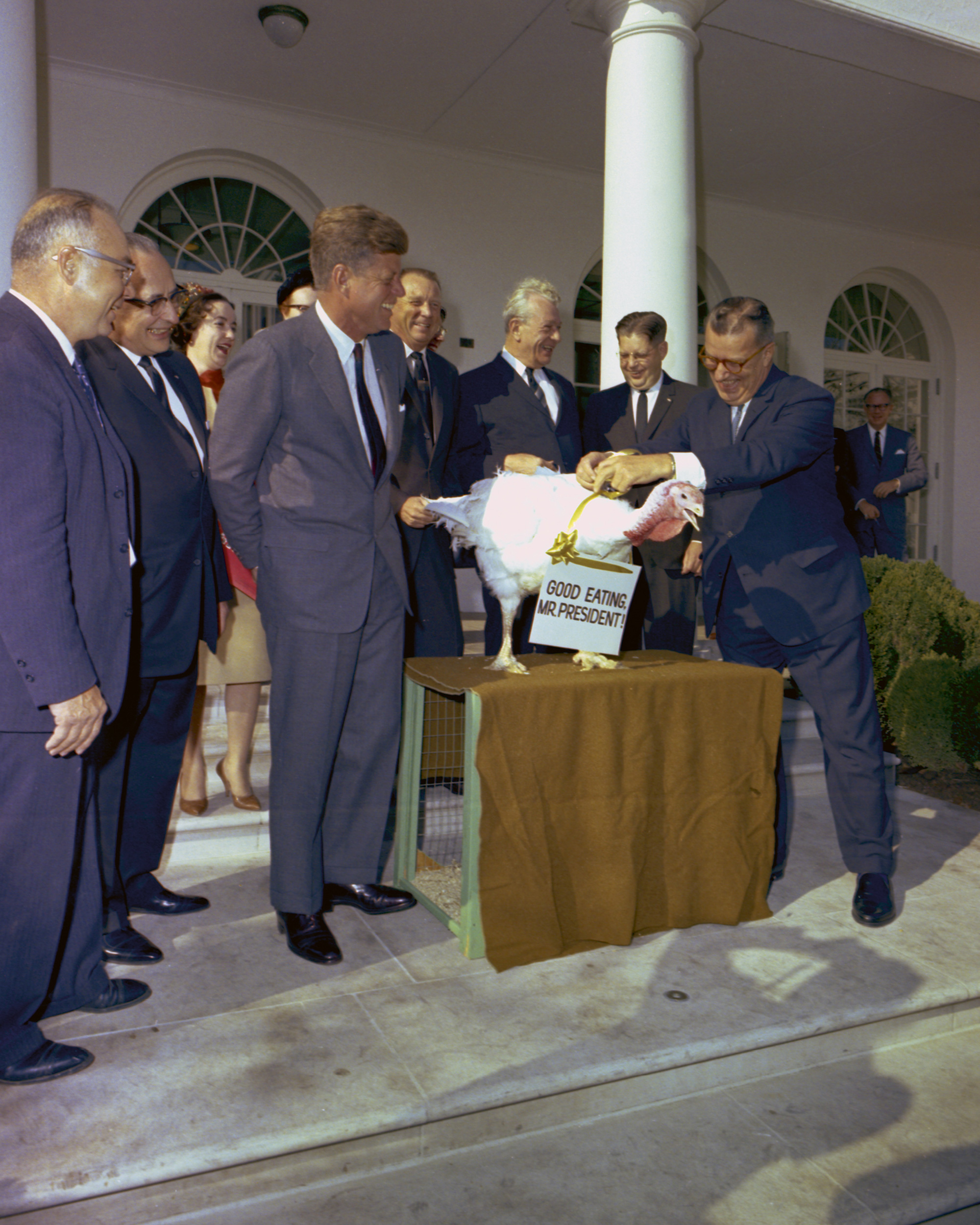 A photograph of the members of the Poultry and Egg National Board and the National Turkey Federation presenting a turkey to President Kennedy on 19 November nineteen sixty-three. This bird was spared by Kennedy, but Steve Plotkin, archivist at the Kennedy Library, states: “It wasn’t an official pardon. It was probably offhand, purely spontaneous.”