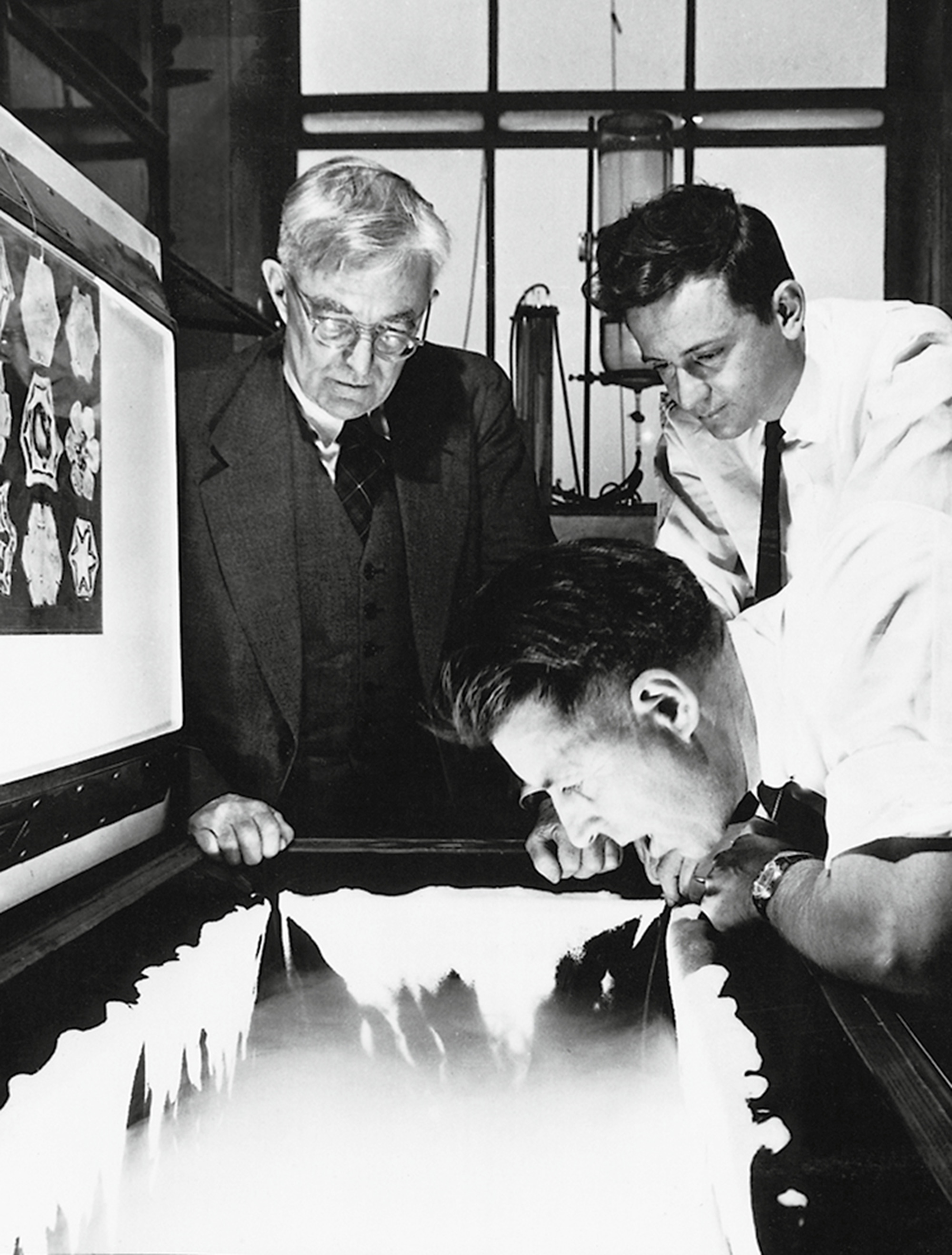 A nineteen forty-seven photograph of the rainmakers Irving Langmuir, Vincent Schaefer, and Bernard Vonnegut at work on cloud seeding in a GE laboratory.