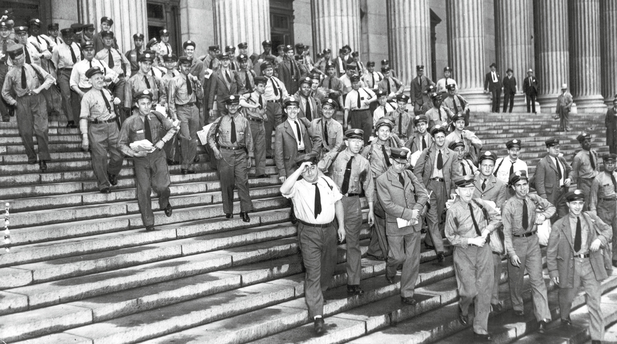 A nineteen thirty-six photograph of letter carriers heading out on their rounds from New York City’s main post office.