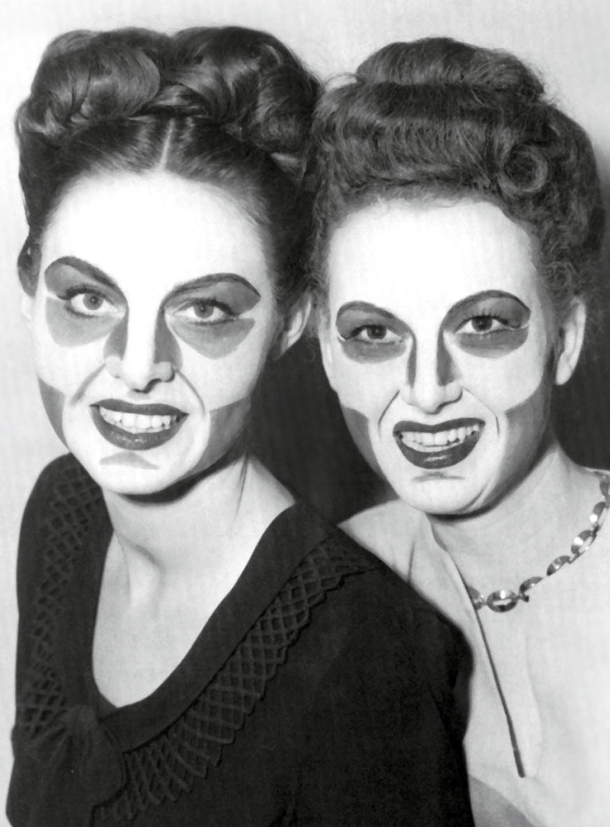 A photograph of two women with painted faces showing the makeup developed in the nineteen forties by Max Factor, Jr., for black-and-white television. Previously, makeup developed for panchromatic film had also been used for television but more sophisticated cameras adopted after World War two were less forgiving of makeup developed for a very different medium. The new cameras, however, transmitted images in negative. The company’s solution was a makeup that looked highly unnatural in real life (to the point that performers often balked at wearing it) but appeared natural when reversed on screen.