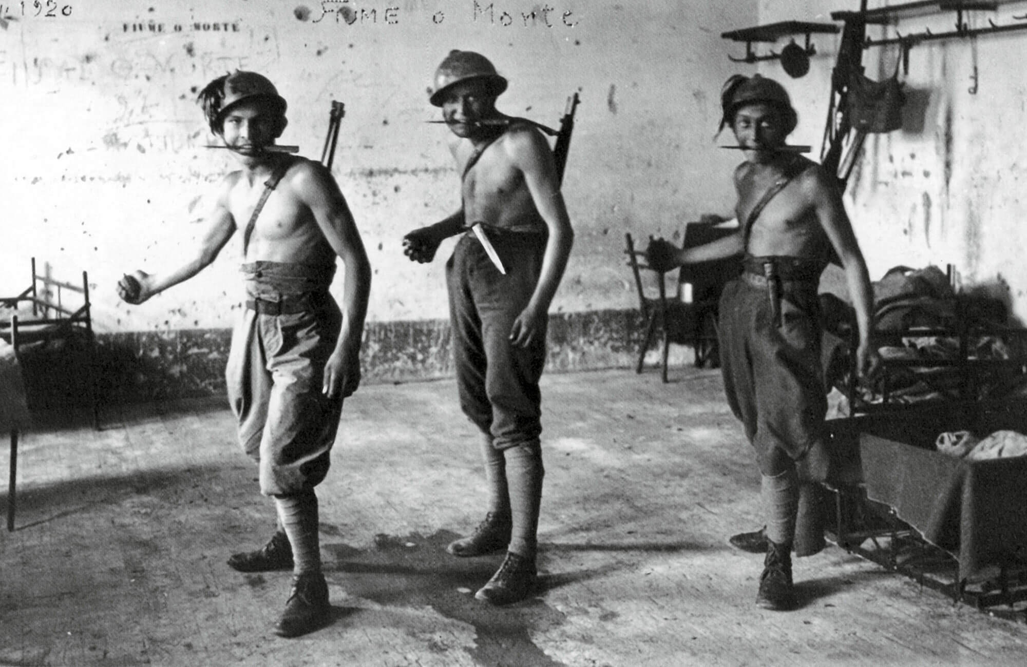 A nineteen twenty photograph of three Fiumean arditi brandishing their weapons of choice.