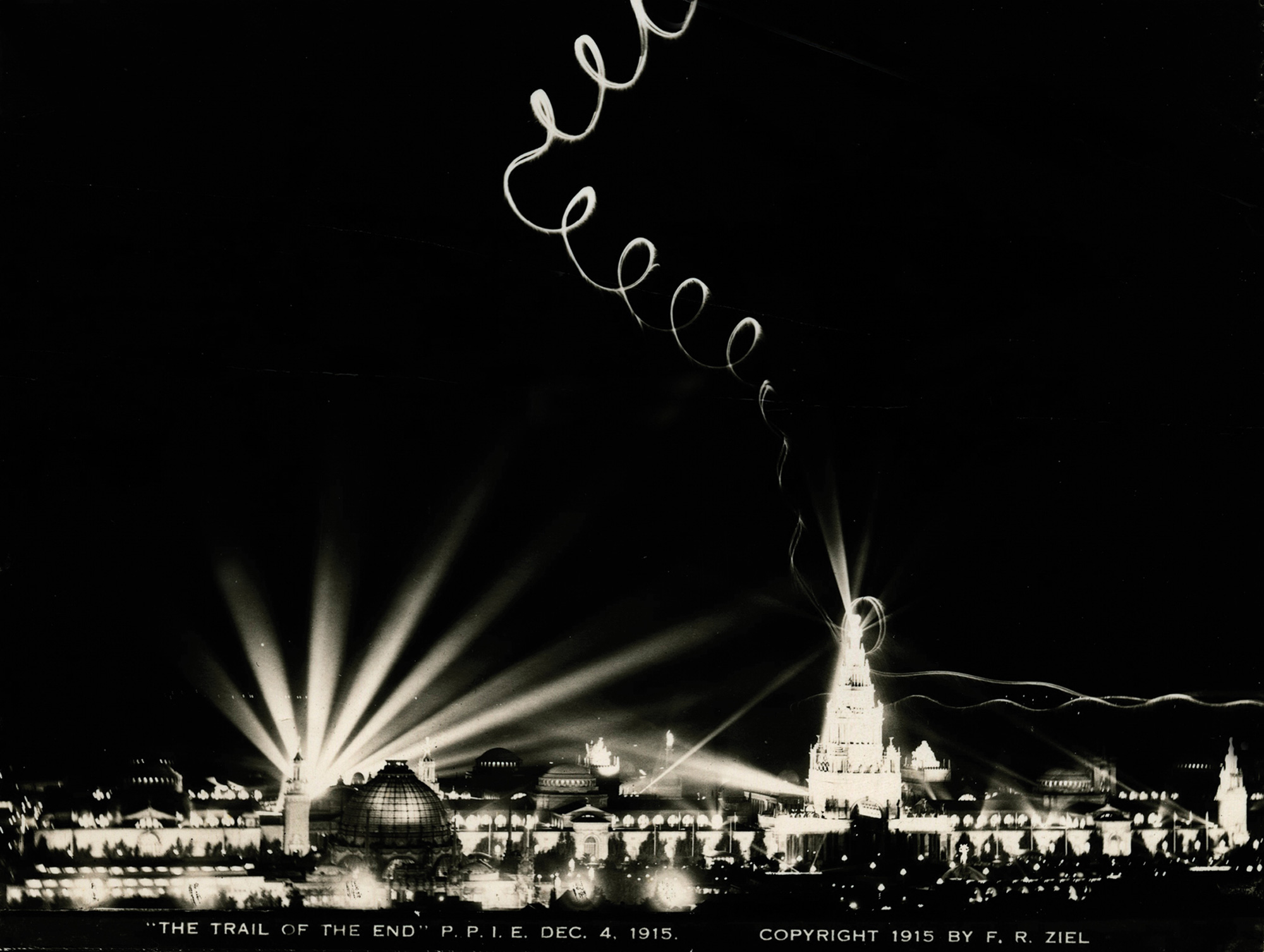 A photograph of skywriting lighting up a night sky from an Art Smith performance on the final evening of the Panama-Pacific International Exposition on December fourth nineteen fifteen. After leaving the exposition in August, he returned in late fall for additional performances.