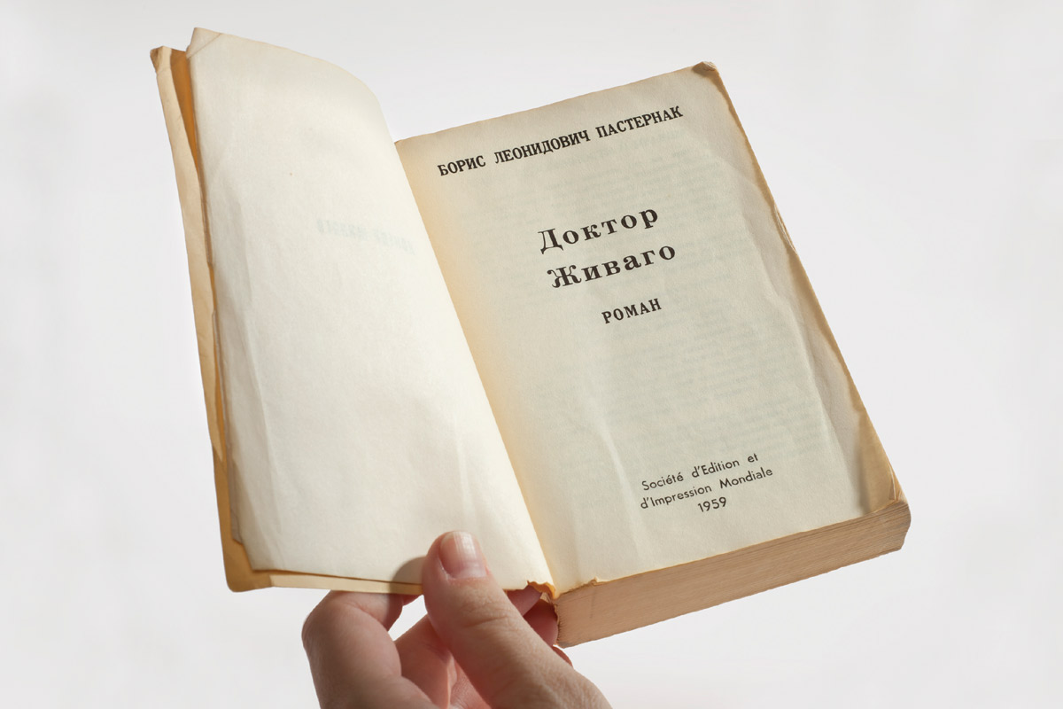 A photograph of a hand opening a copy of the Russian-language edition of Boris Pasternak’s novel 