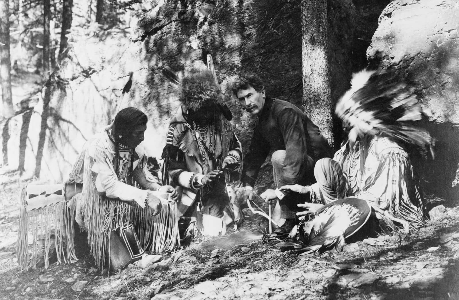 A photograph of Ernest Thompson Seton posing with three citizens of the Blackfeet Nation, thought to have been taken in nineteen seventeen.