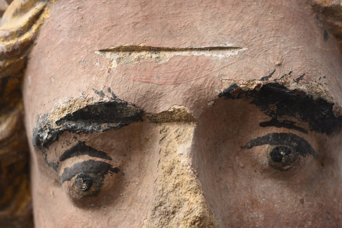 Photograph of the painted head of a bishop, one of more than four hundred and fifty pieces of broken sculpture found inside the walls of Saint Cuthbert’s Church in Wells, Somerset, in eighteen forty-eight. Destroyed by iconoclasts in the sixteenth century and then plastered into the church walls, the sculptural elements were recovered during the course of a renovation.