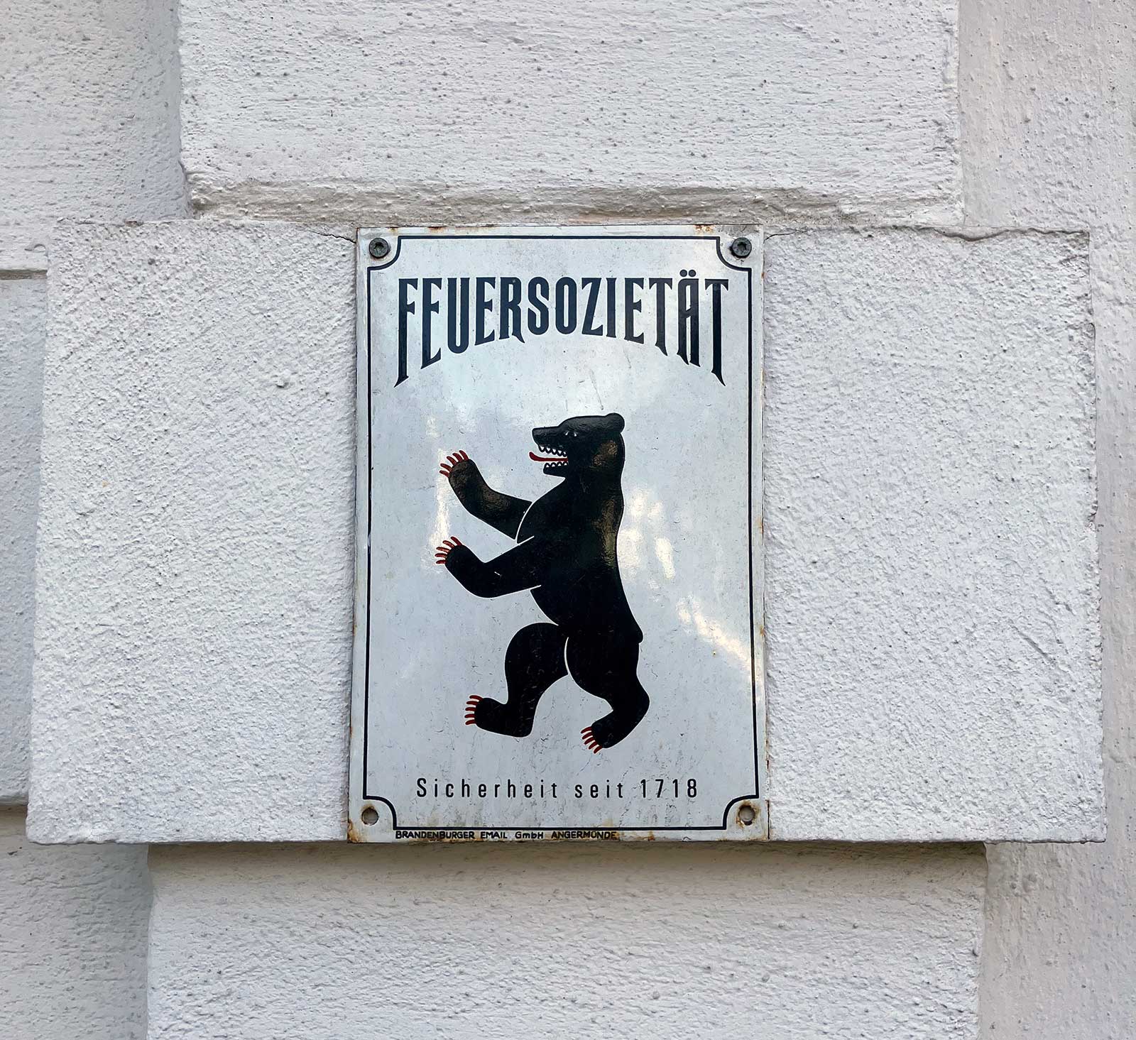 A photograph of a postwar Berliner Fire Society sign featuring the imperial bear.
