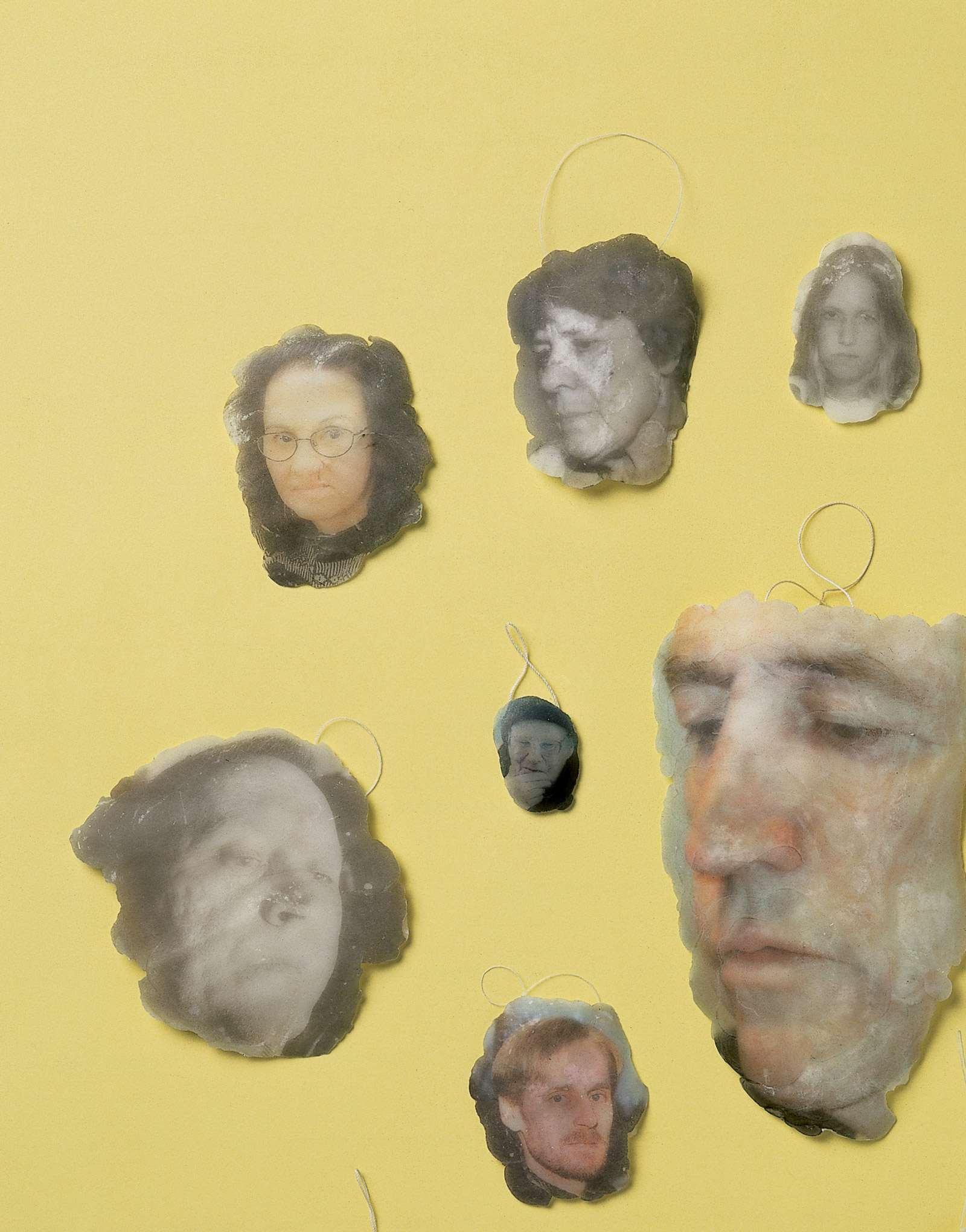A photograph of fourteen wax medallions, each bearing a photographic image of a face. The medallions were produced by dropping hot wax on photographs of faces in newspapers, thus transferring each image onto the wax. The medallions are part of The Disappointed and the Offended, an artist project by Magnus Bärtås included in this issue’s theme section on Failure.
