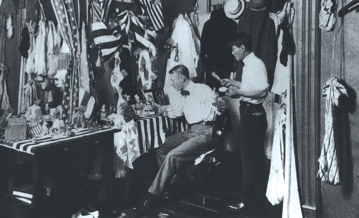 A photograph of Geroge M. Cohan and his longtime valet Michio “Mike” Hirano in Cohan’s flag-bedecked dressing room.