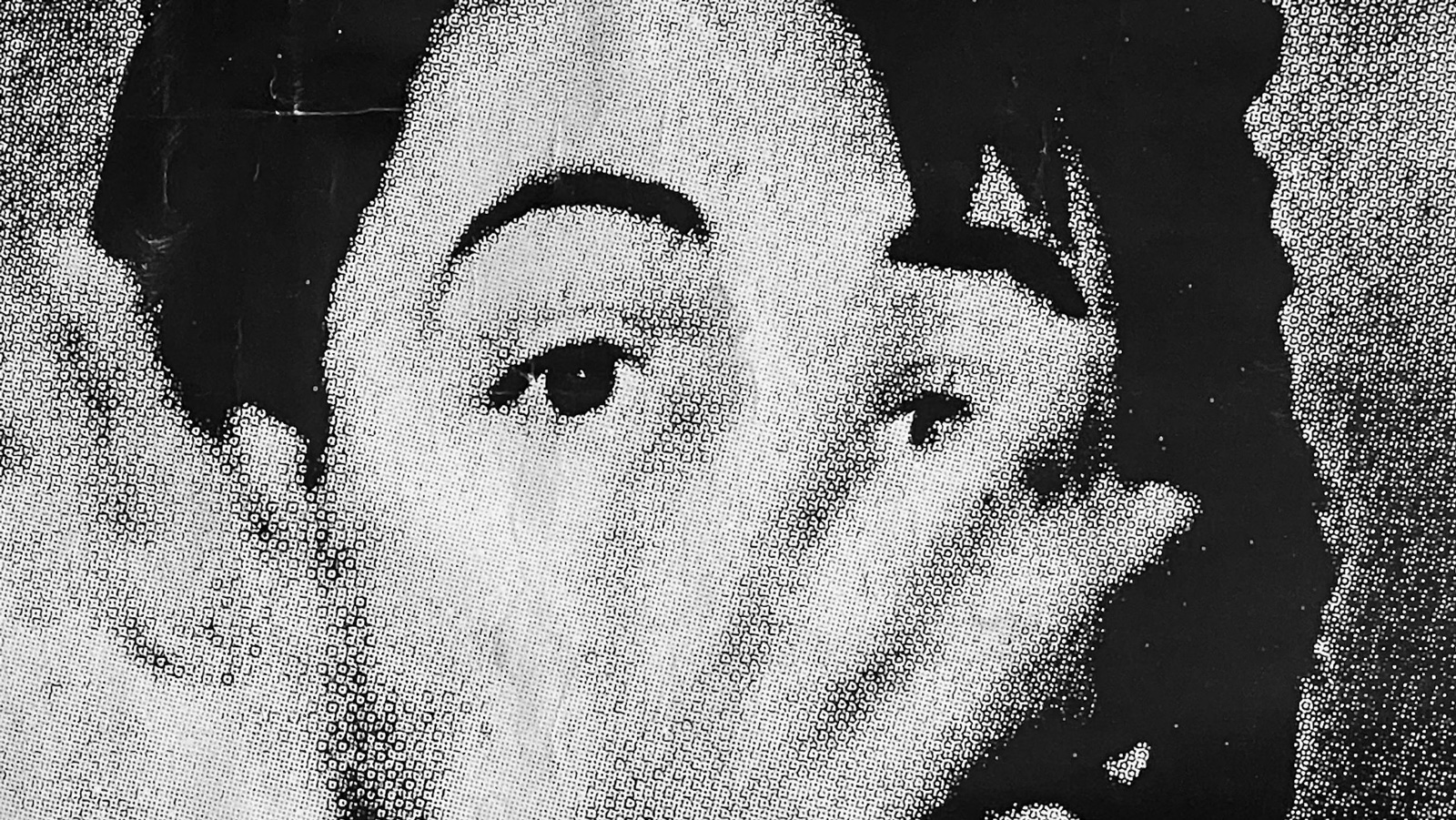 An unknown man partially obscures his face with his hand