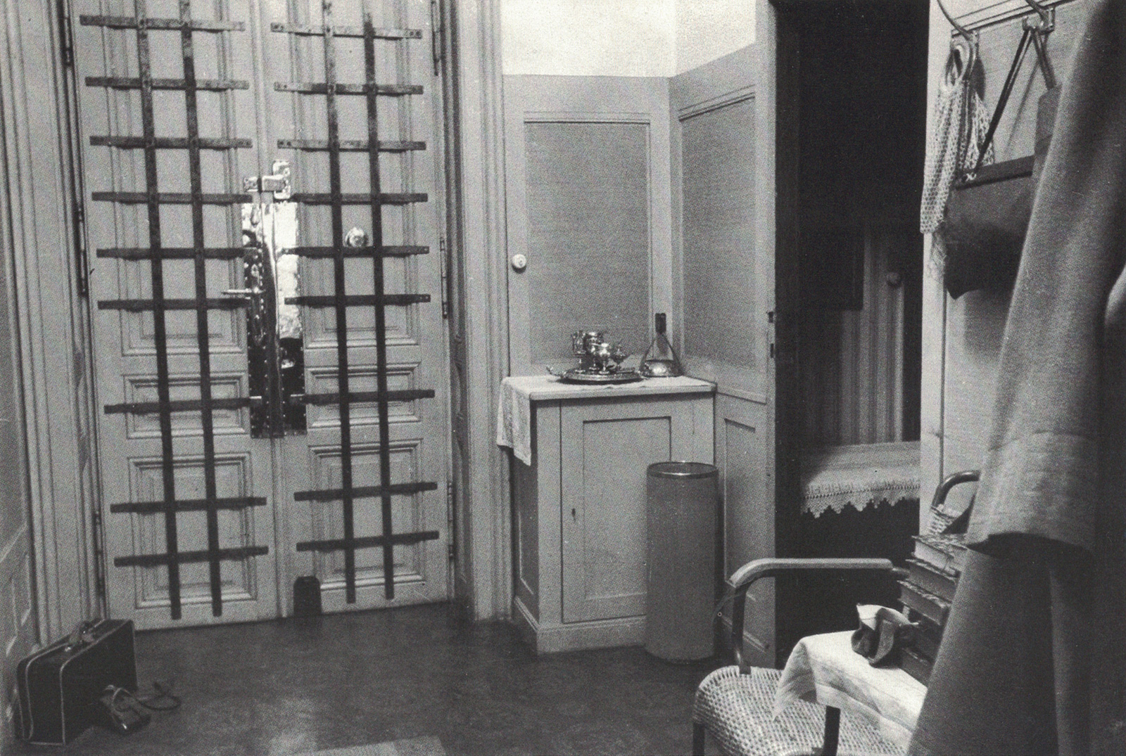 A photograph of the iron-grilled entrance door to Freud’s practice with Freud’s valise and Engelman’s camera case on the floor.