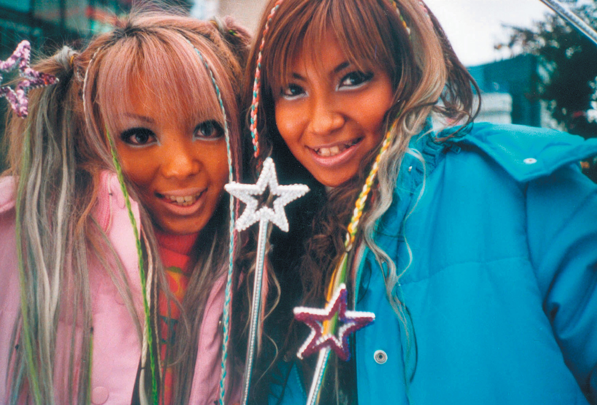 A Lomographic image depicting two girls wearing colorful makeup.