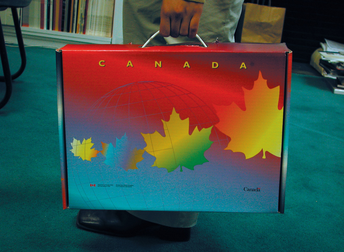 A photograph of a rectangular box with a handle, like a briefcase, with a maple leaf design and the word Canada on it.