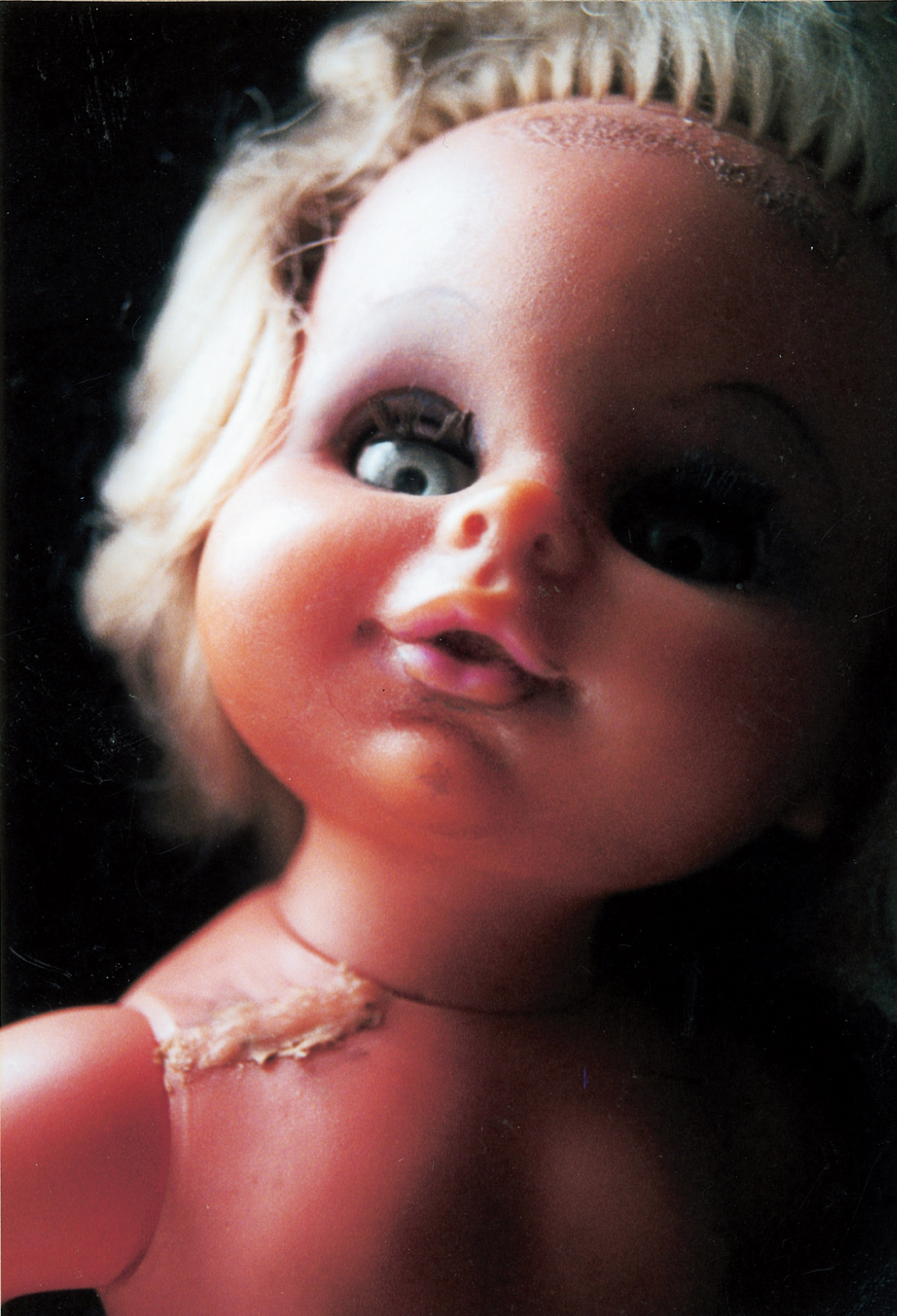 A photograph depicting a close-up detail of a female doll named Matron. The caption reads: The Doll Games’ Sadean baby doll, a cruel voluptuary who presided over the orphanages and boarding schools of the so-called “nasty” games, corrupting virtuous boy dolls and jealously tormenting rivals Aina, Mara, and Melanie. At once mother-substitute and gargantuan infant, Matron was a key element in the Doll Games’ studies of the “maternal grotesque” as well as the “infant whore,” while the surrogate families she ruled became Oedipal laboratories in which the Doll Games conducted many of their boldest experiments.
